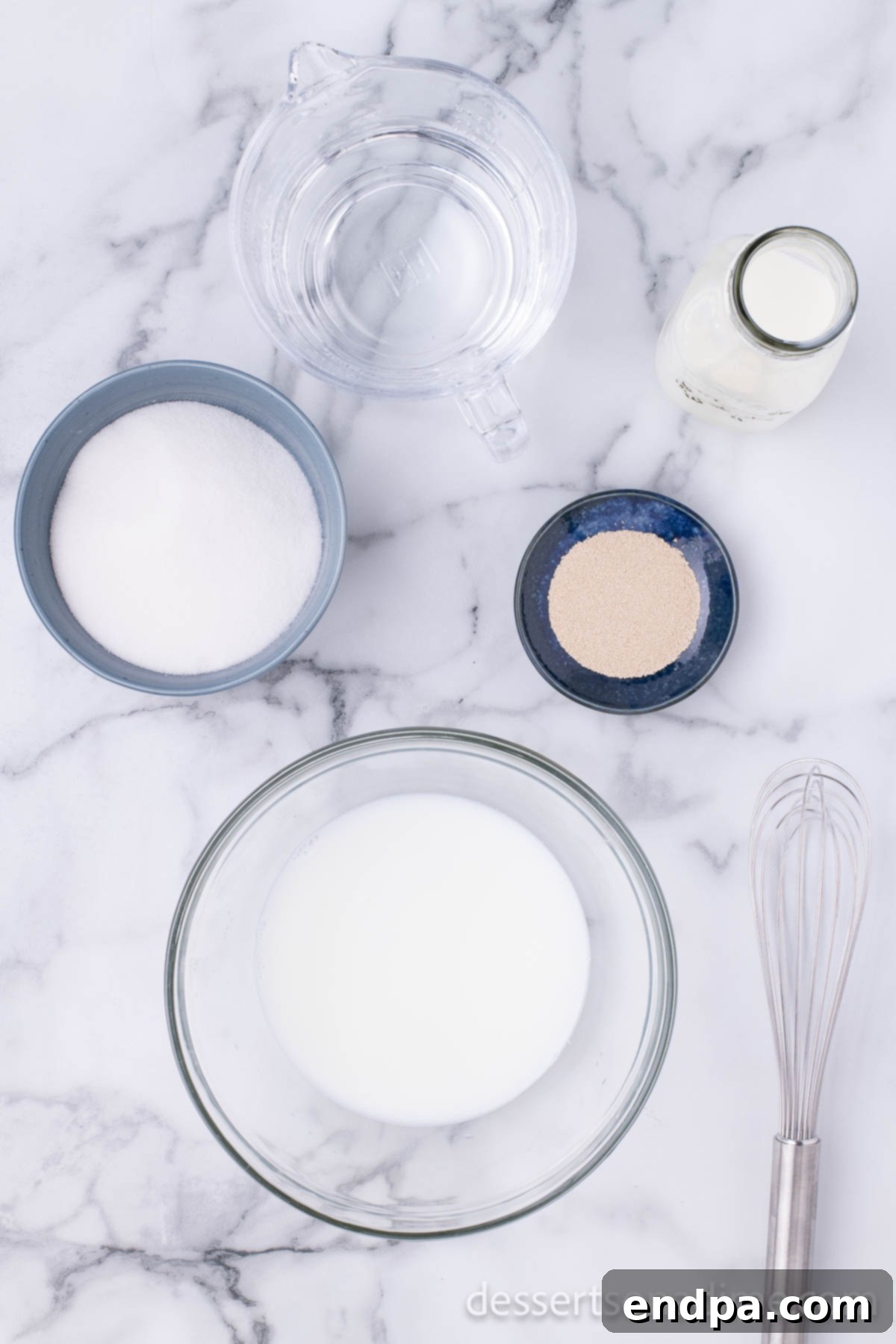 Krispy Kreme Donut Bites 4 A bowl containing a liquid mixture of milk and boiling water, the initial step for activating yeast in donut dough.