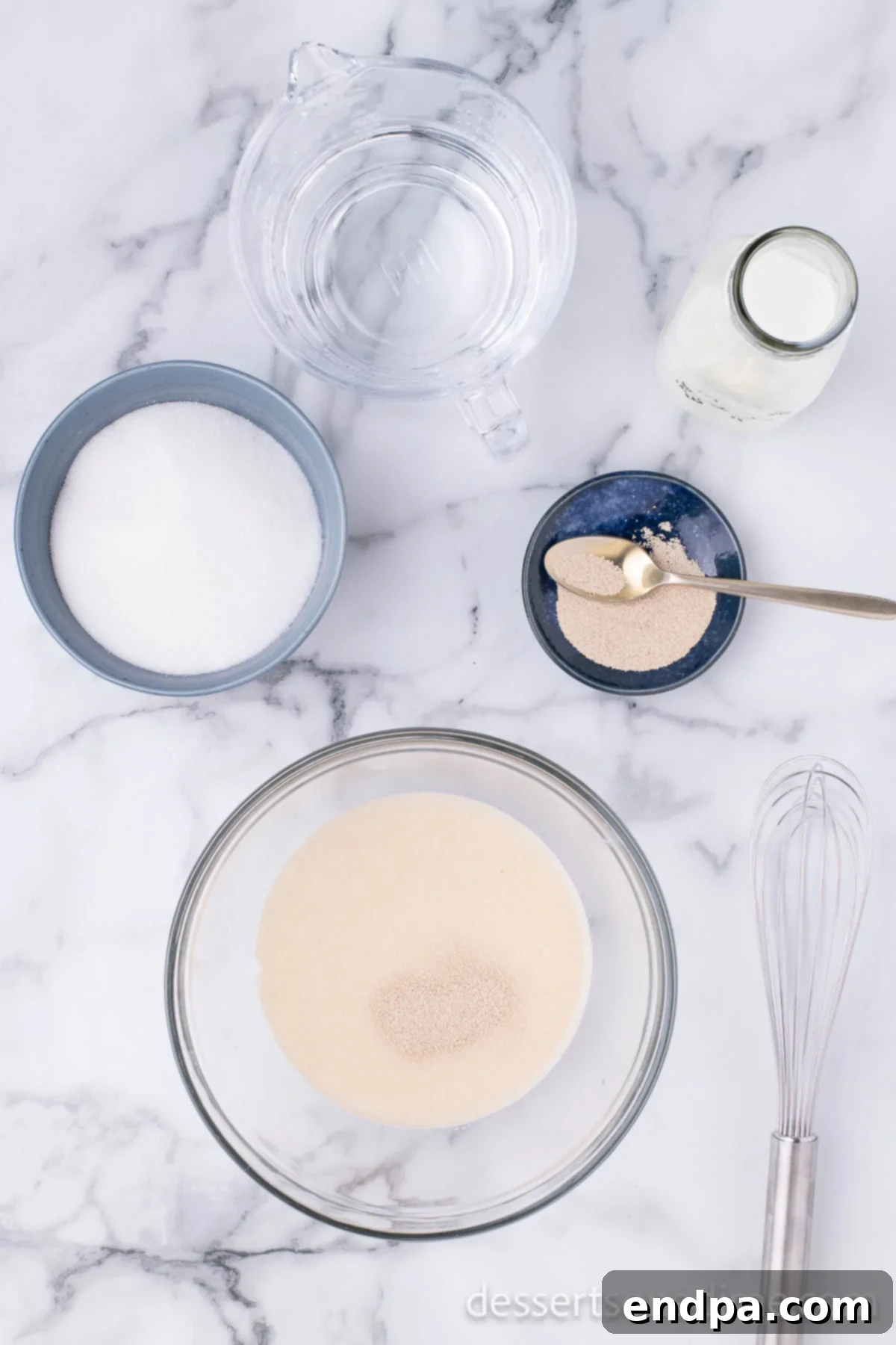 Krispy Kreme Donut Bites 5 Yeast and sugar being stirred into the milk and water mixture in a bowl, crucial for the dough's rise.