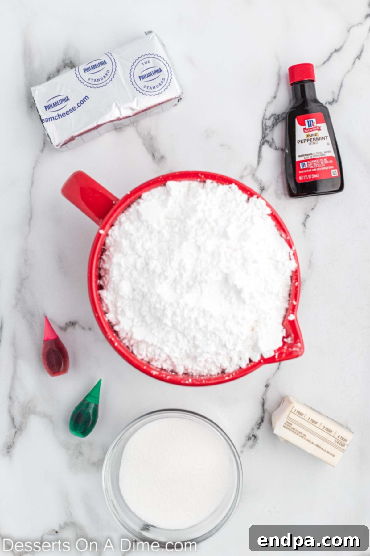 Ingredients for homemade Christmas mints including cream cheese, powdered sugar, vanilla, food coloring, and butter.