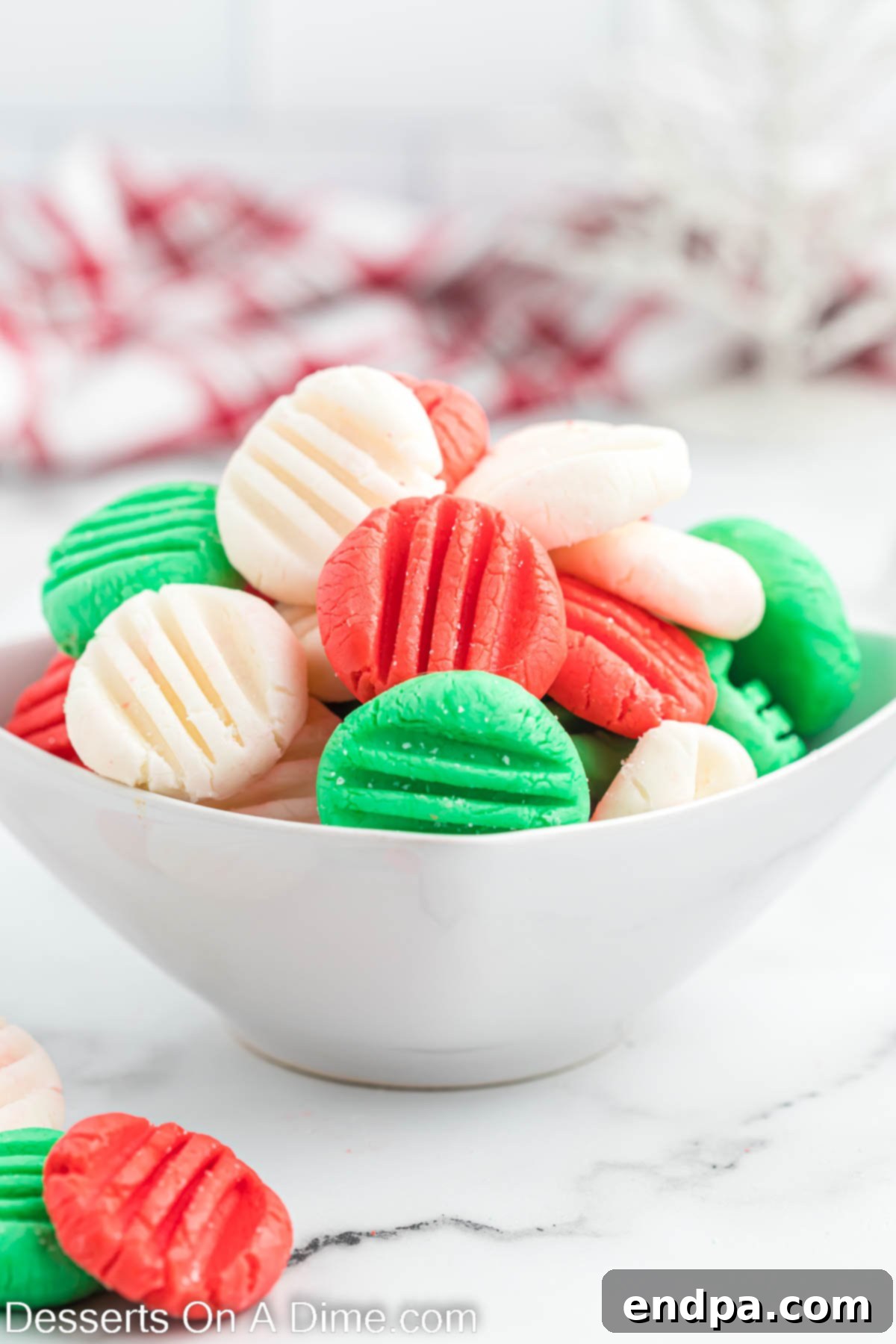 Another view of the festive red, green, and white Christmas mints in a serving bowl, showcasing their inviting texture.