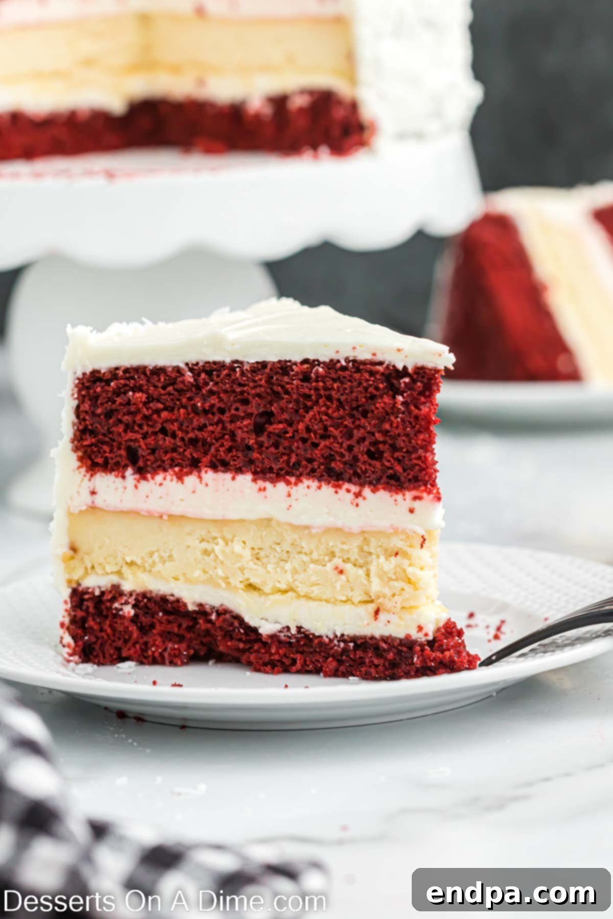 A delectable slice of Red Velvet Cheesecake, revealing its beautiful layers, served on a plate with a fork.