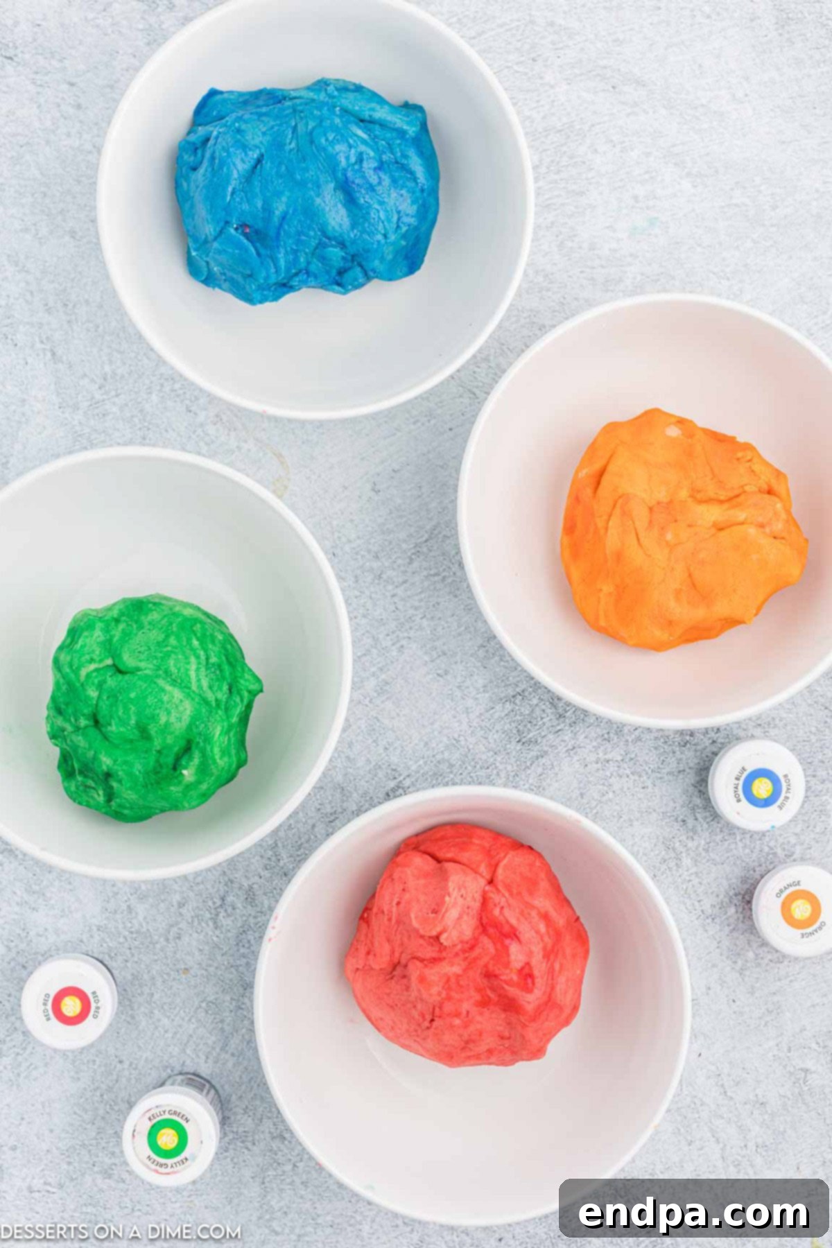 Vibrant Jello Bites 6 Cookie dough divided into bowls with different Jell-O colors being mixed in.