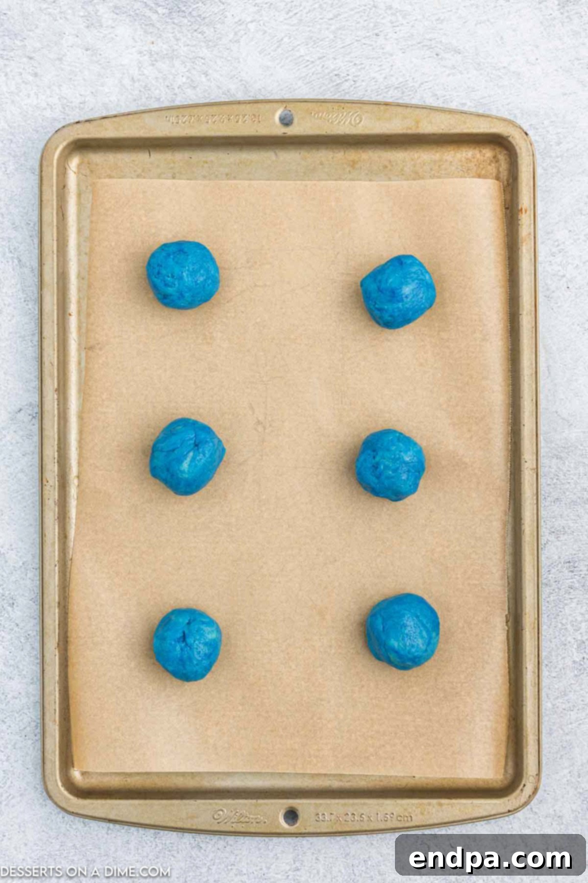 Vibrant Jello Bites 7 Small balls of colored cookie dough placed on a baking sheet.