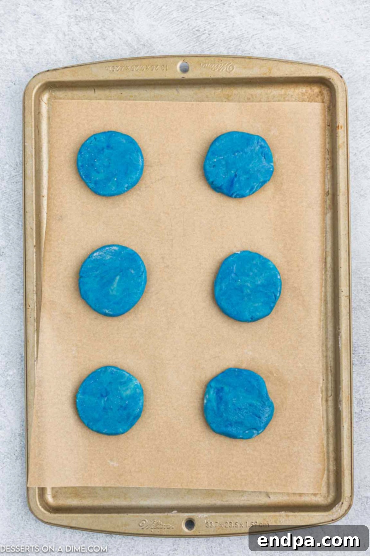 Vibrant Jello Bites 8 Flattened cookie dough balls on a baking sheet, ready for baking.