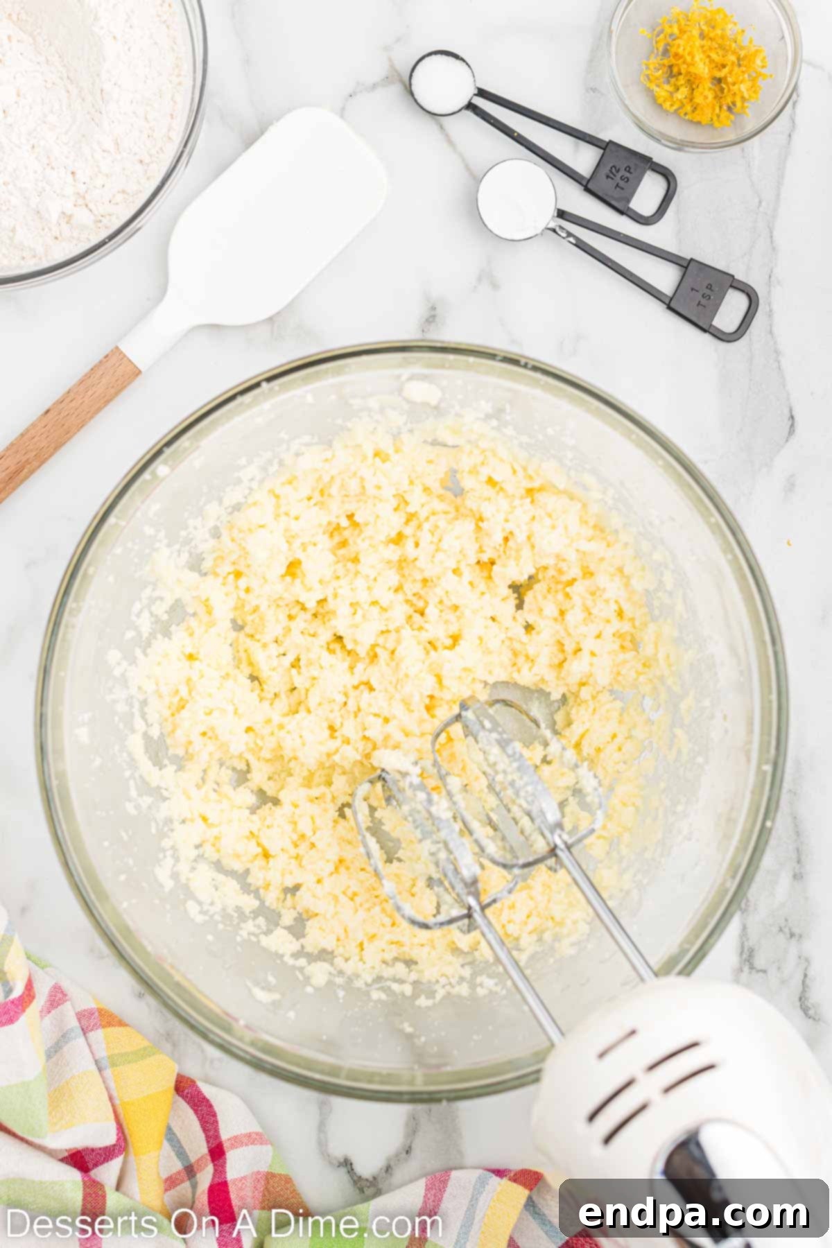 A bowl with softened butter and granulated sugar being creamed together.