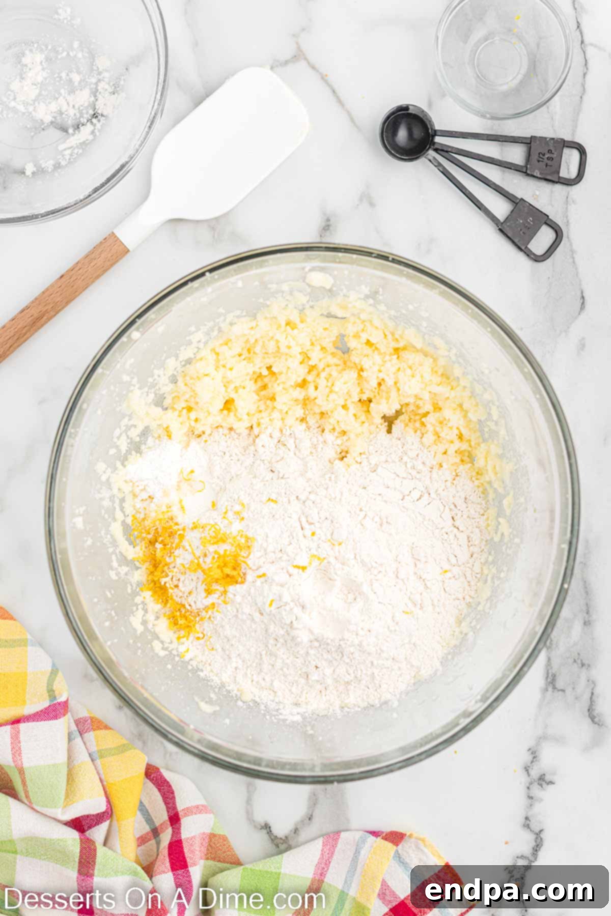 Bowl with wet ingredients (egg, vanilla, lemon juice, milk) mixed with creamed butter and sugar, then dry ingredients added.