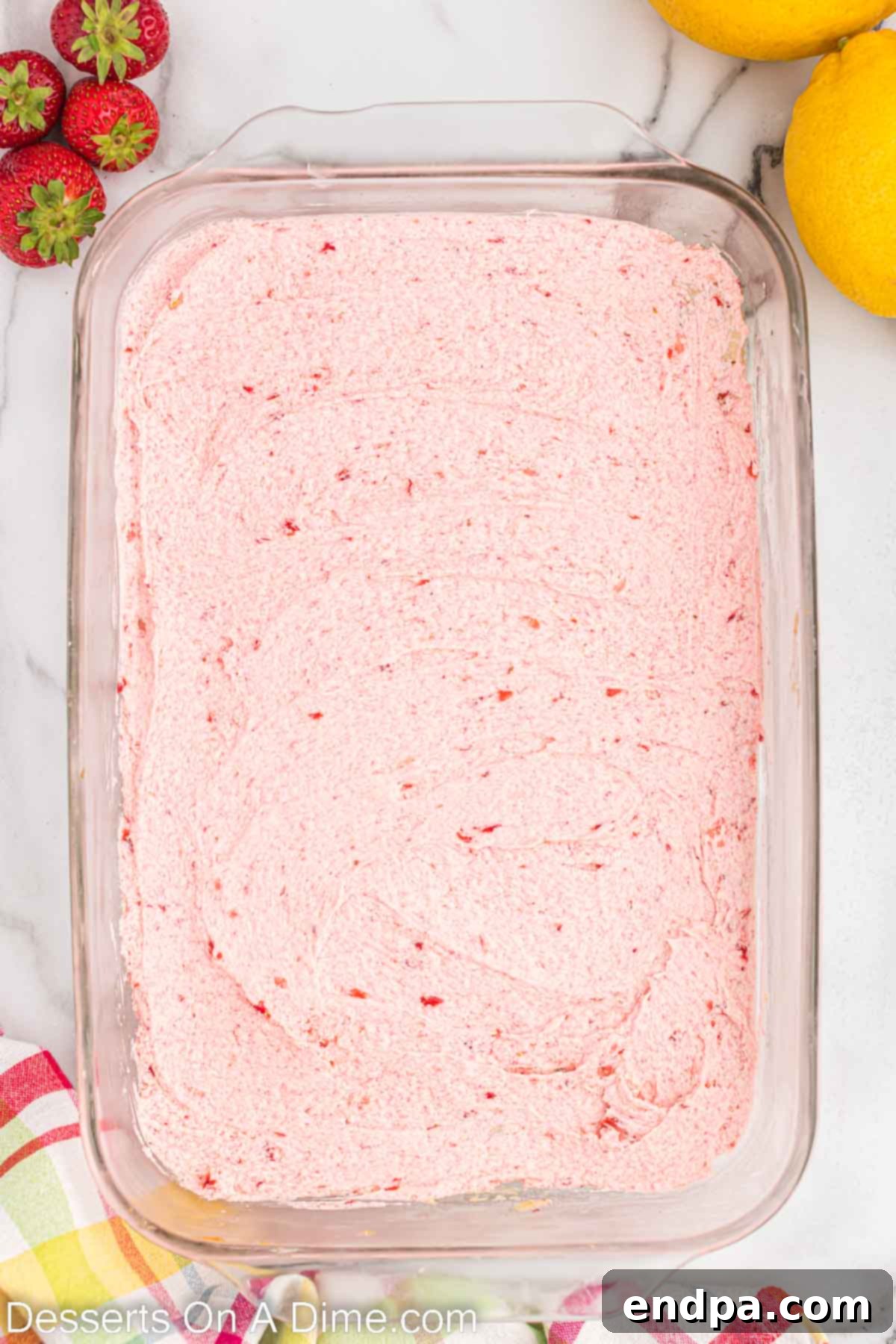 Strawberry frosting spread smoothly over the cooled lemon sugar cookie bars.
