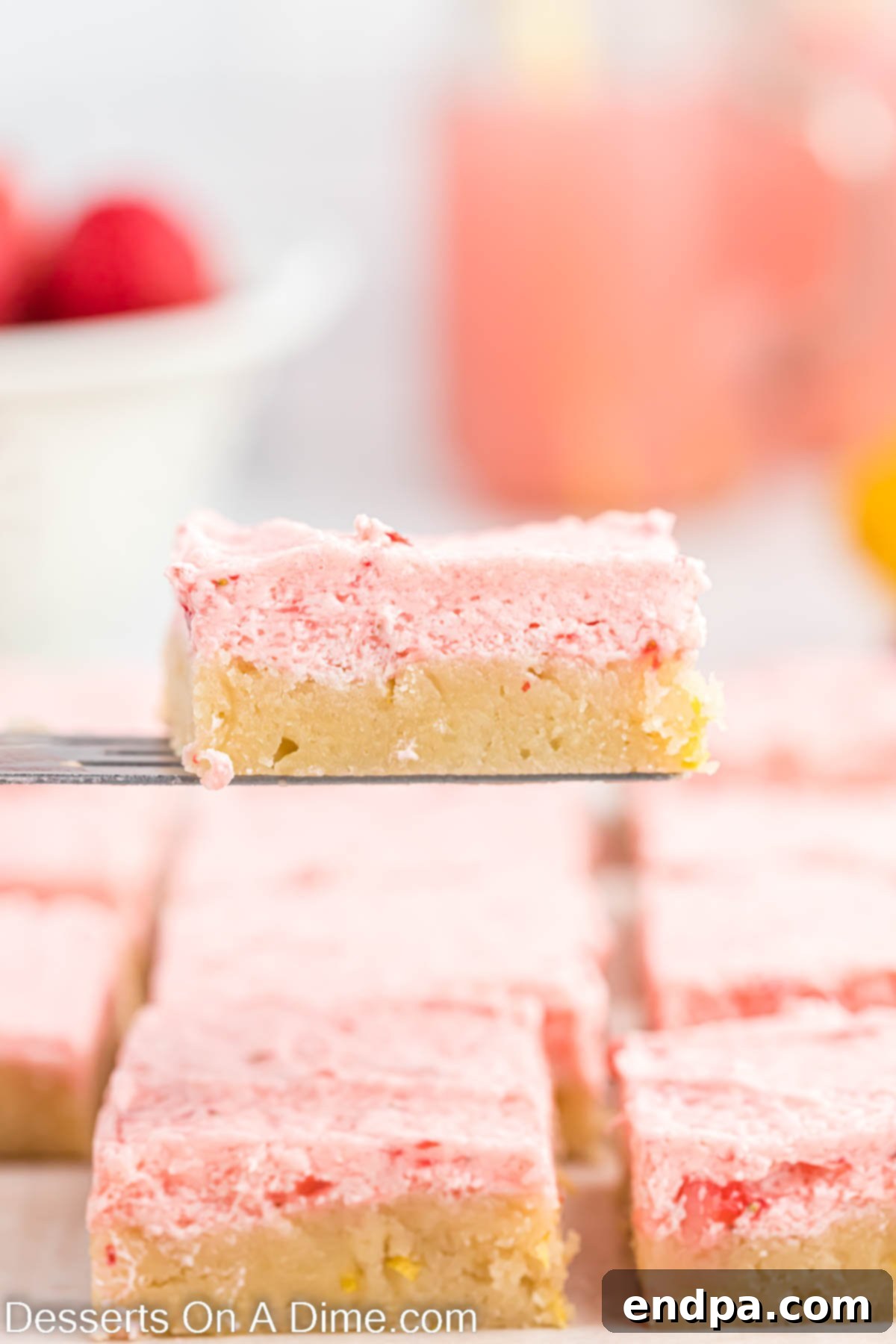 Strawberry Lemonade Sugar Cookie Bars being sliced and served with a spatula.