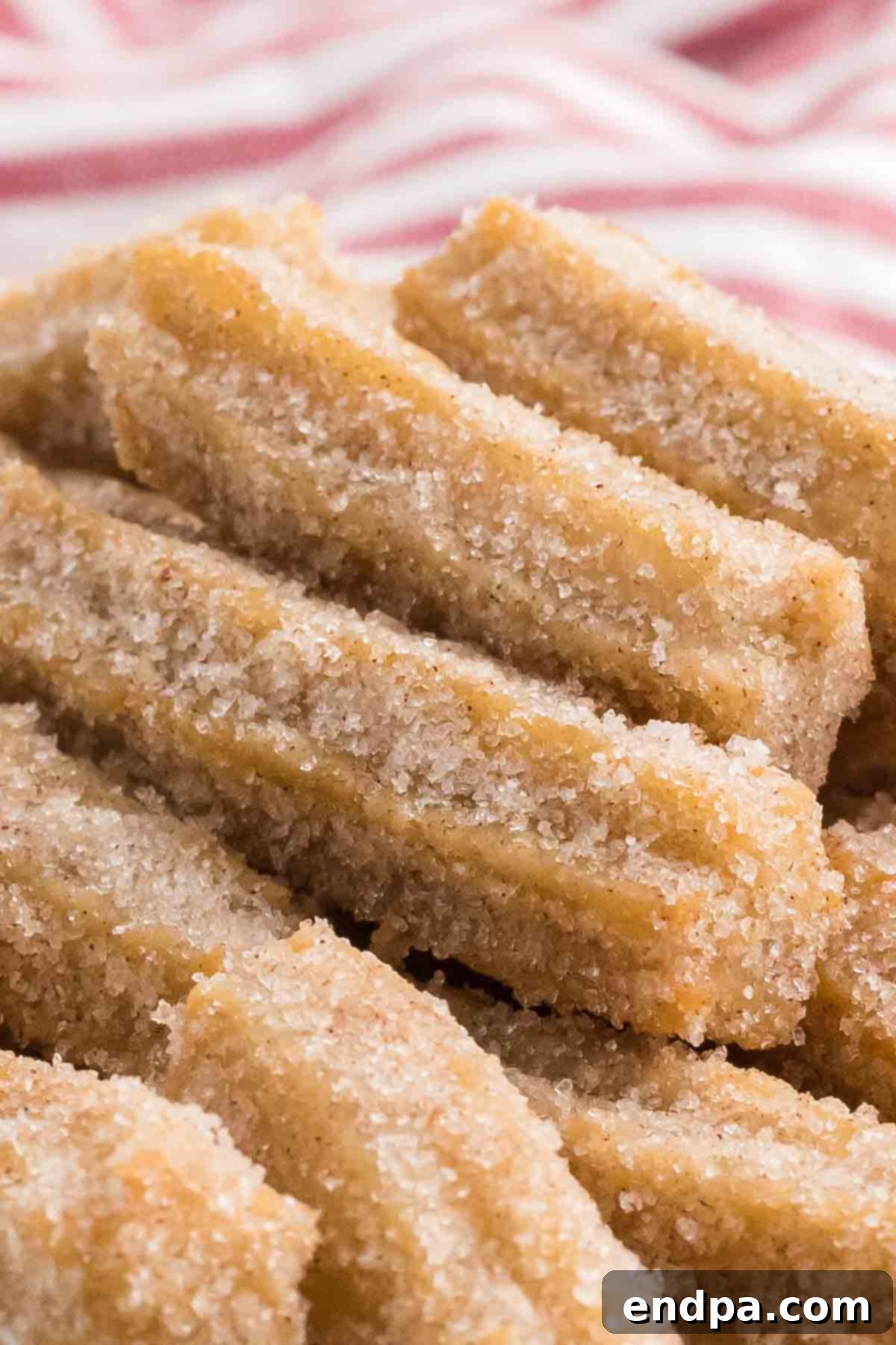 Close-up view of golden brown churro bites coated in cinnamon sugar.