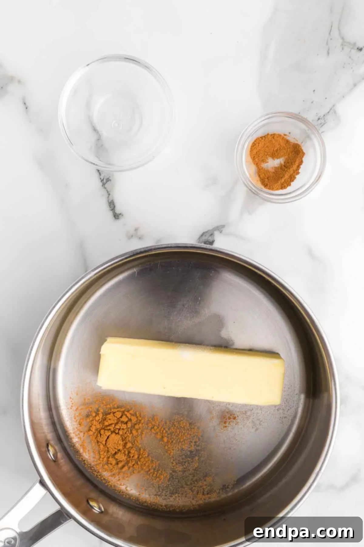 Butter, water, cinnamon, and salt in a saucepan, ready to melt.