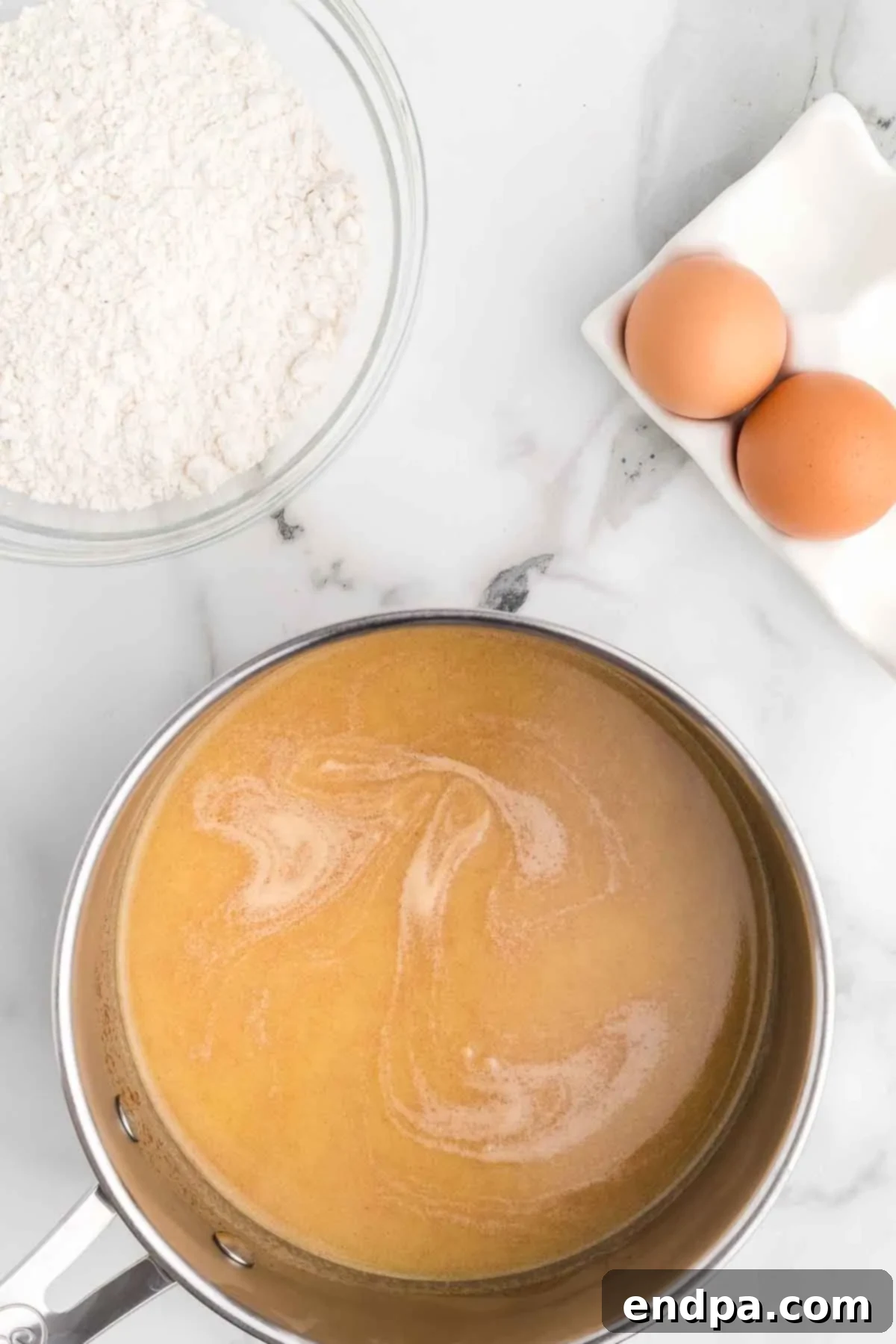 Water, butter, cinnamon, and salt mixture brought to a boil in a saucepan.