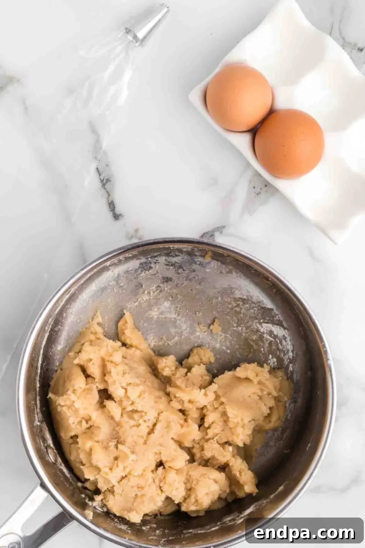 Flour added to the wet mixture, forming a dough ball in the pan.