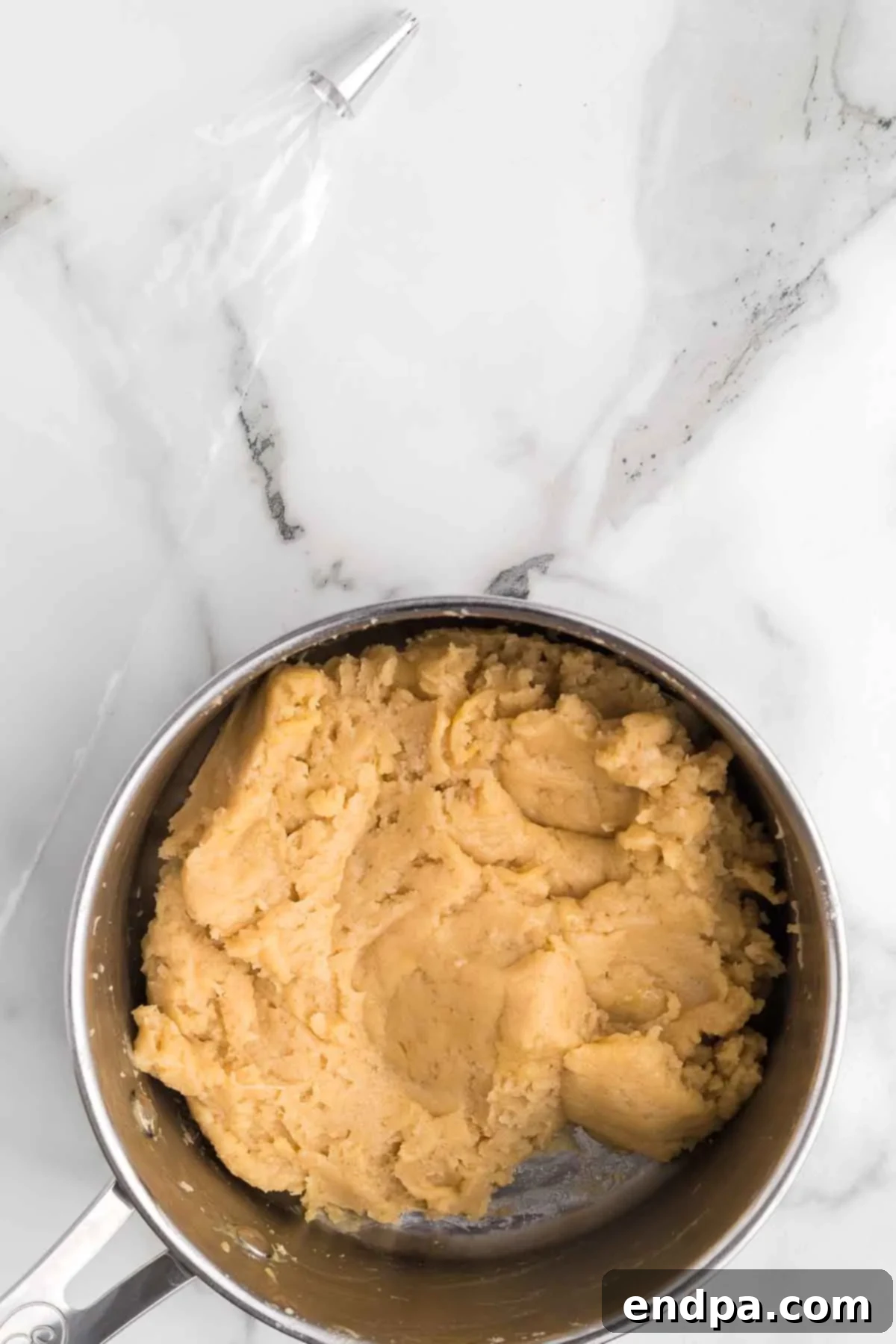Fully combined churro dough mixture in a saucepan, ready for piping.