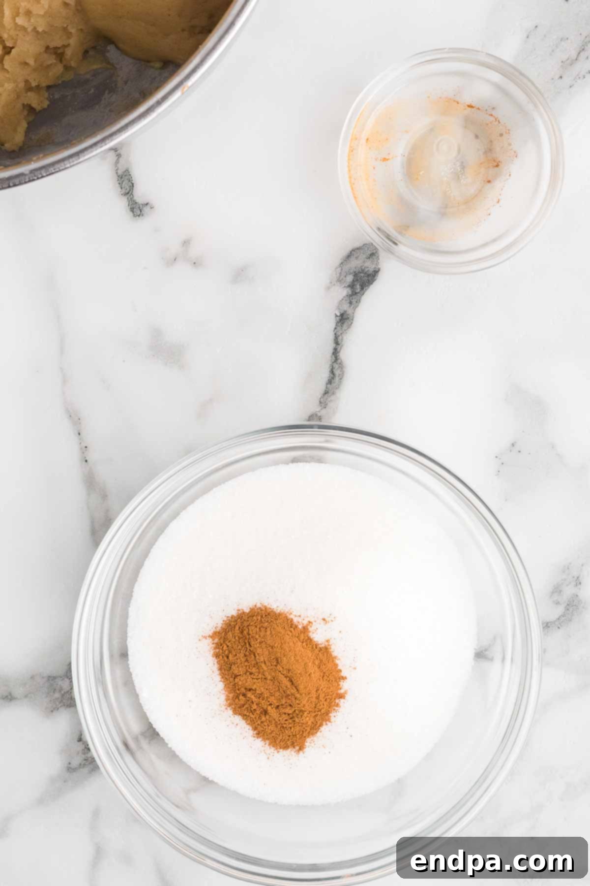 Cinnamon and granulated sugar mixed in a shallow dish for coating churros.