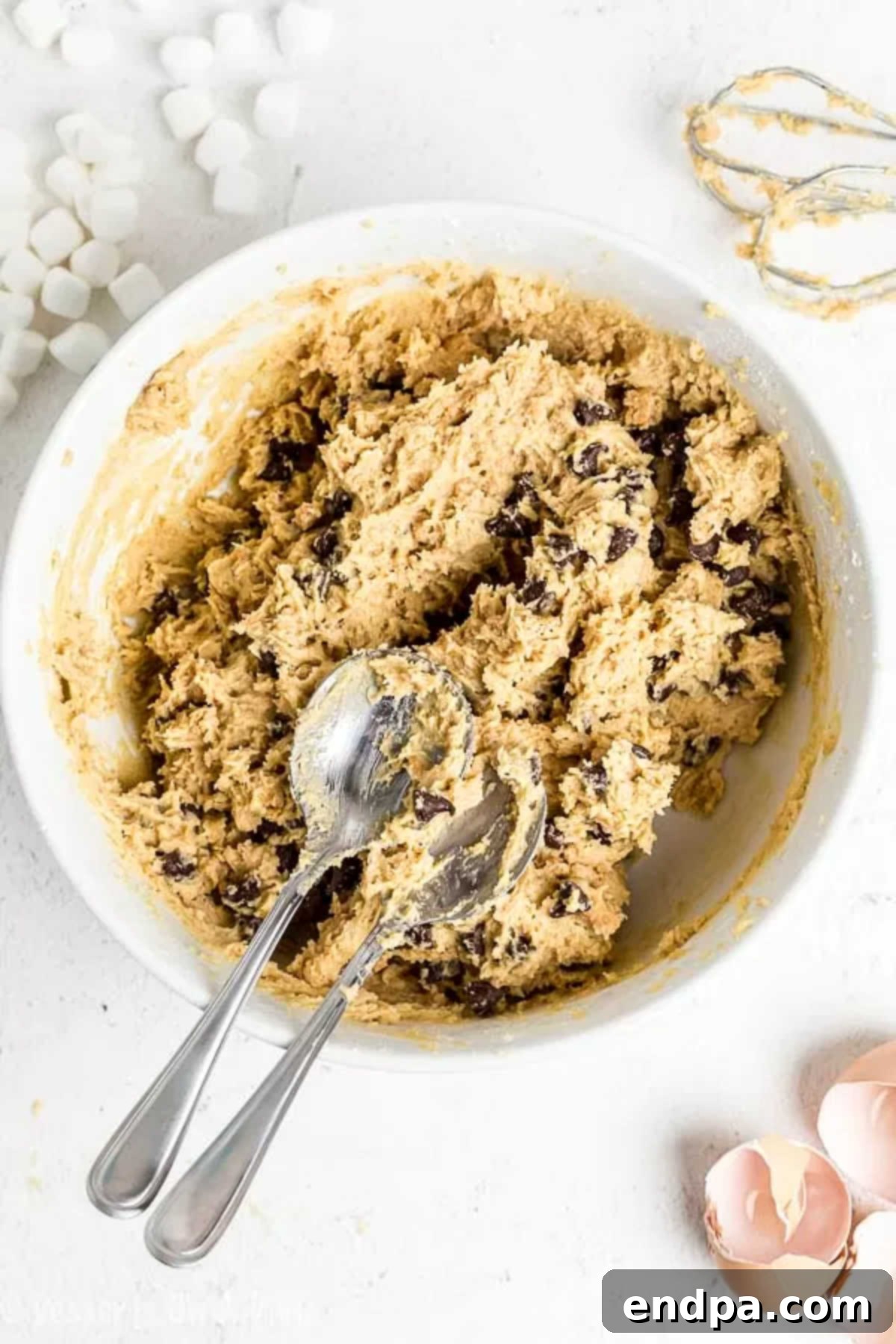 Campfire Smores Cookies 4 Scooped portions of s'mores cookie dough are neatly arranged on a baking sheet, ready to be formed into balls and baked.