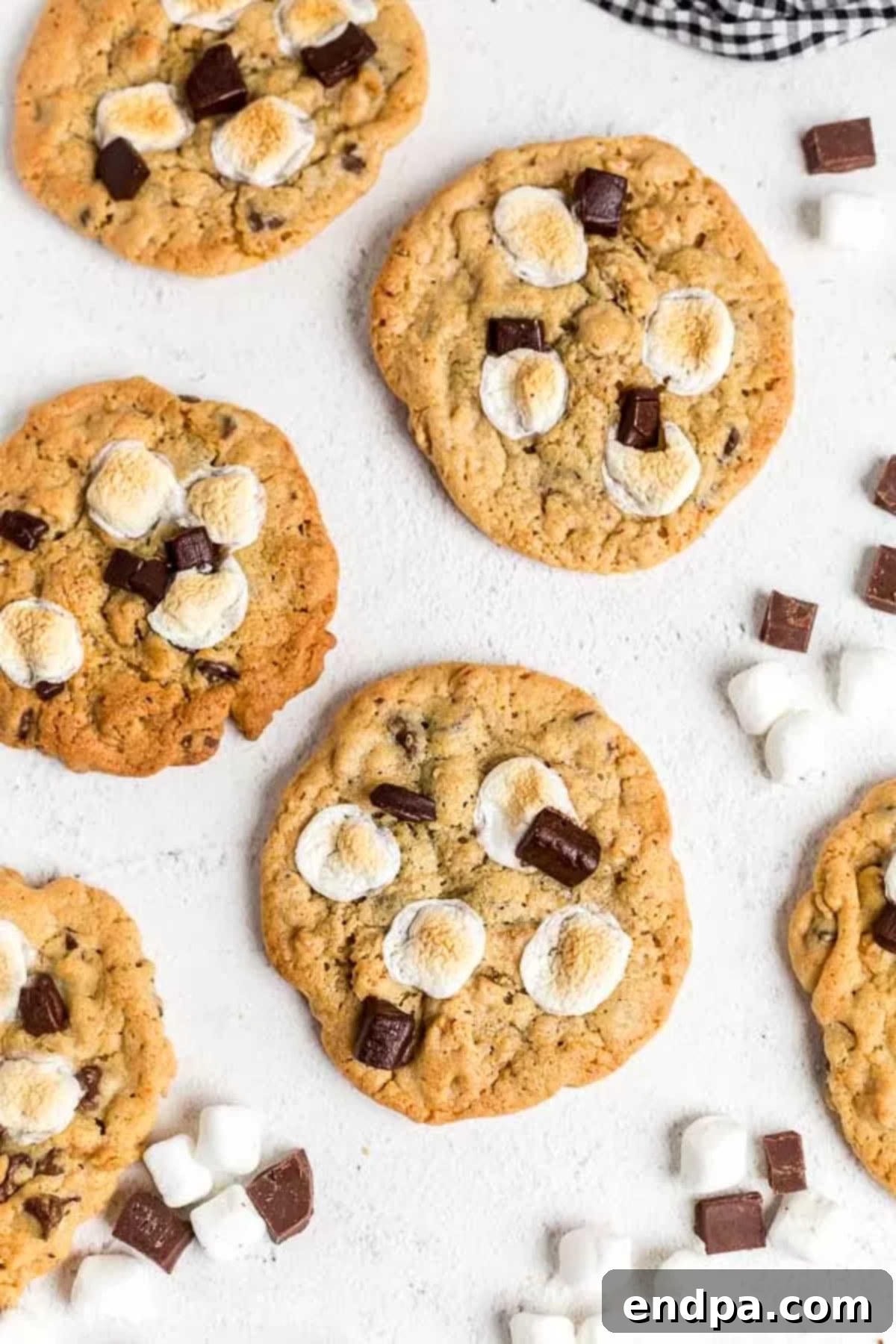 Everything you love about s'mores is packed into this tasty S'mores Cookies Recipe. Each bite is ooey gooey with lots of chocolate, marshmallows and more! An inviting close-up of a stack of golden-brown s'mores cookies, highlighting their soft texture, melted chocolate, and caramelized marshmallows.