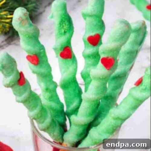 Grinchmas Dessert Delights 15 Grinch Pretzels, green coated pretzels with red heart sprinkles.