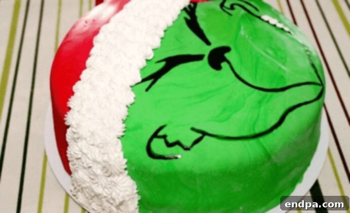 Grinchmas Dessert Delights 20 A slice of green Grinch Cake with red frosting and sprinkles.