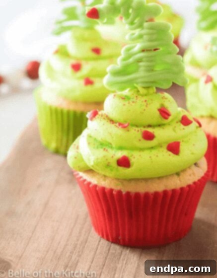 Grinchmas Dessert Delights 23 Grinch Cupcakes with green frosting, sprinkles, and a small Whoville tree.