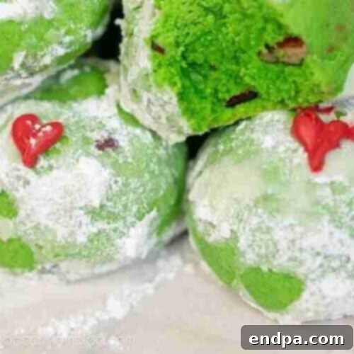 Grinchmas Dessert Delights 25 Grinch Snowball Cookies, green and dusted with powdered sugar.