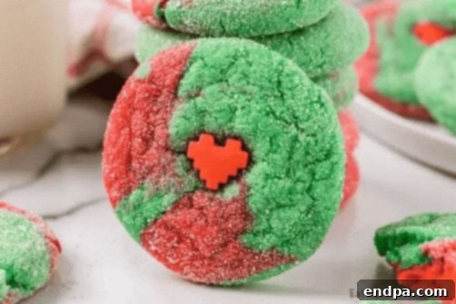 Grinchmas Dessert Delights 4 Green crinkle cookies with powdered sugar, a Grinch Cake Mix Cookie.