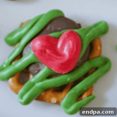 Grinchmas Dessert Delights 6 Close-up of individual green Grinch bites decorated with red hearts.