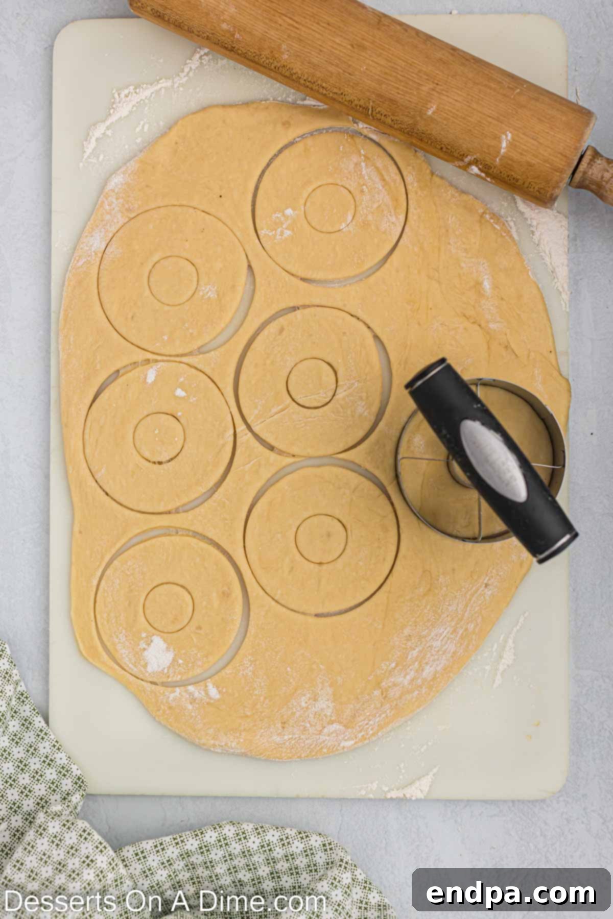 Doughnut cutter being used to make donut shapes.