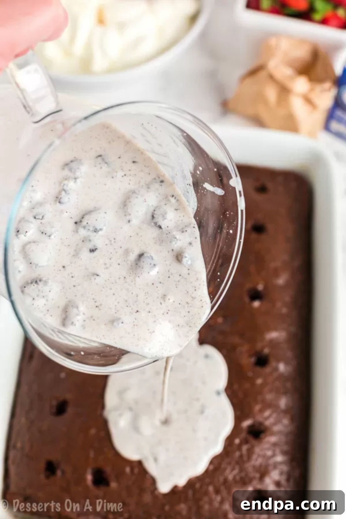 Filling being poured on the poke cake into the holes. 