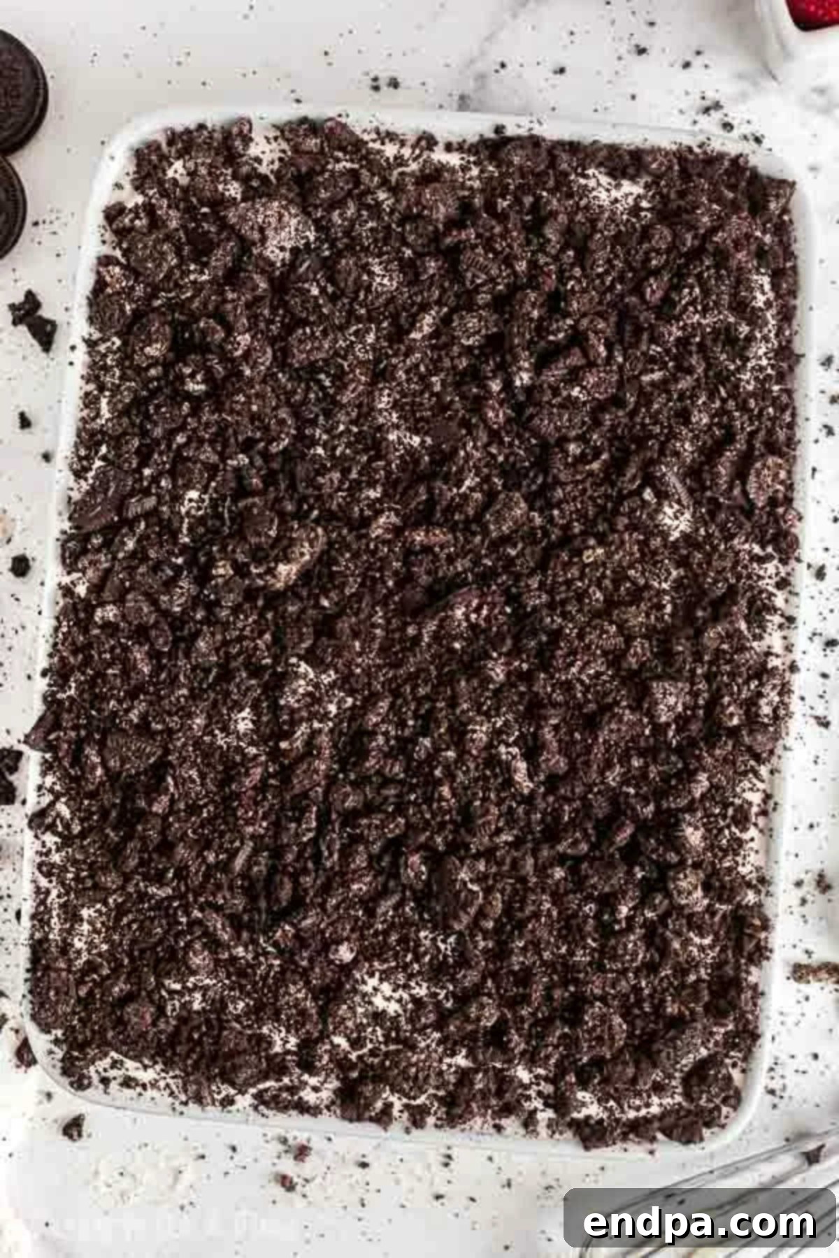 Crushed Oreo Cookies sprinkled on top of cake. 