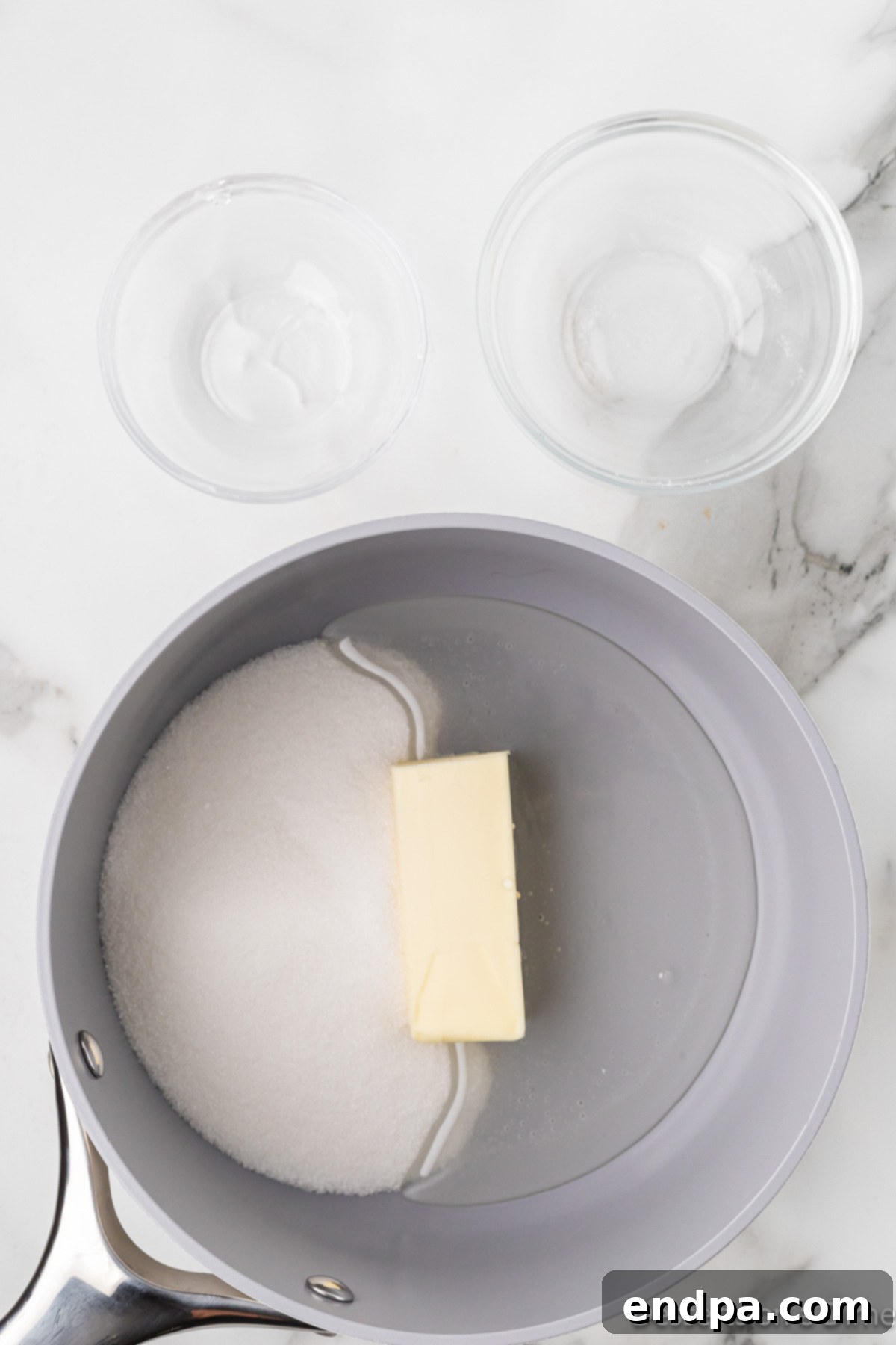 Butter, sugar, and corn syrup combined in a saucepan, ready to be heated.