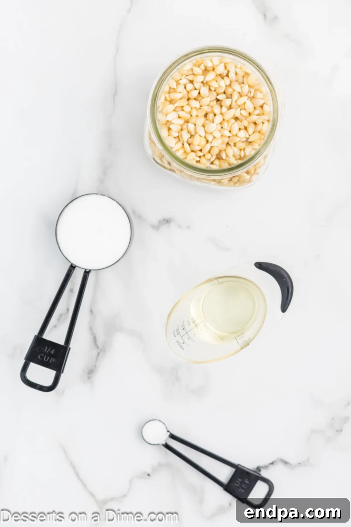 Sweet & Salty Kettle Corn 3 Four essential ingredients for homemade kettle corn: vegetable oil, popcorn kernels, sugar, and salt, displayed in small bowls.