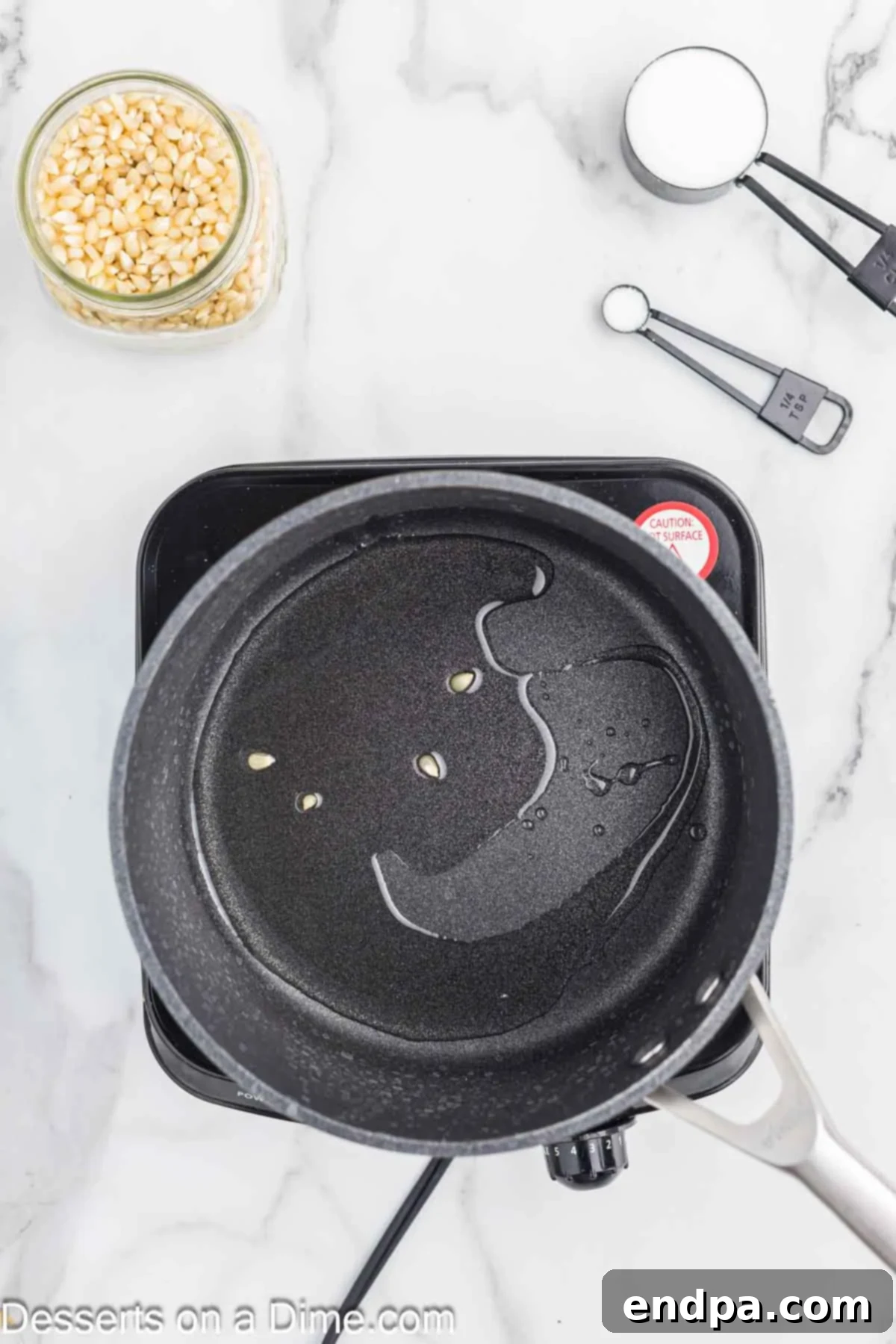 Sweet & Salty Kettle Corn 4 Vegetable oil heating in a large saucepan on the stovetop.