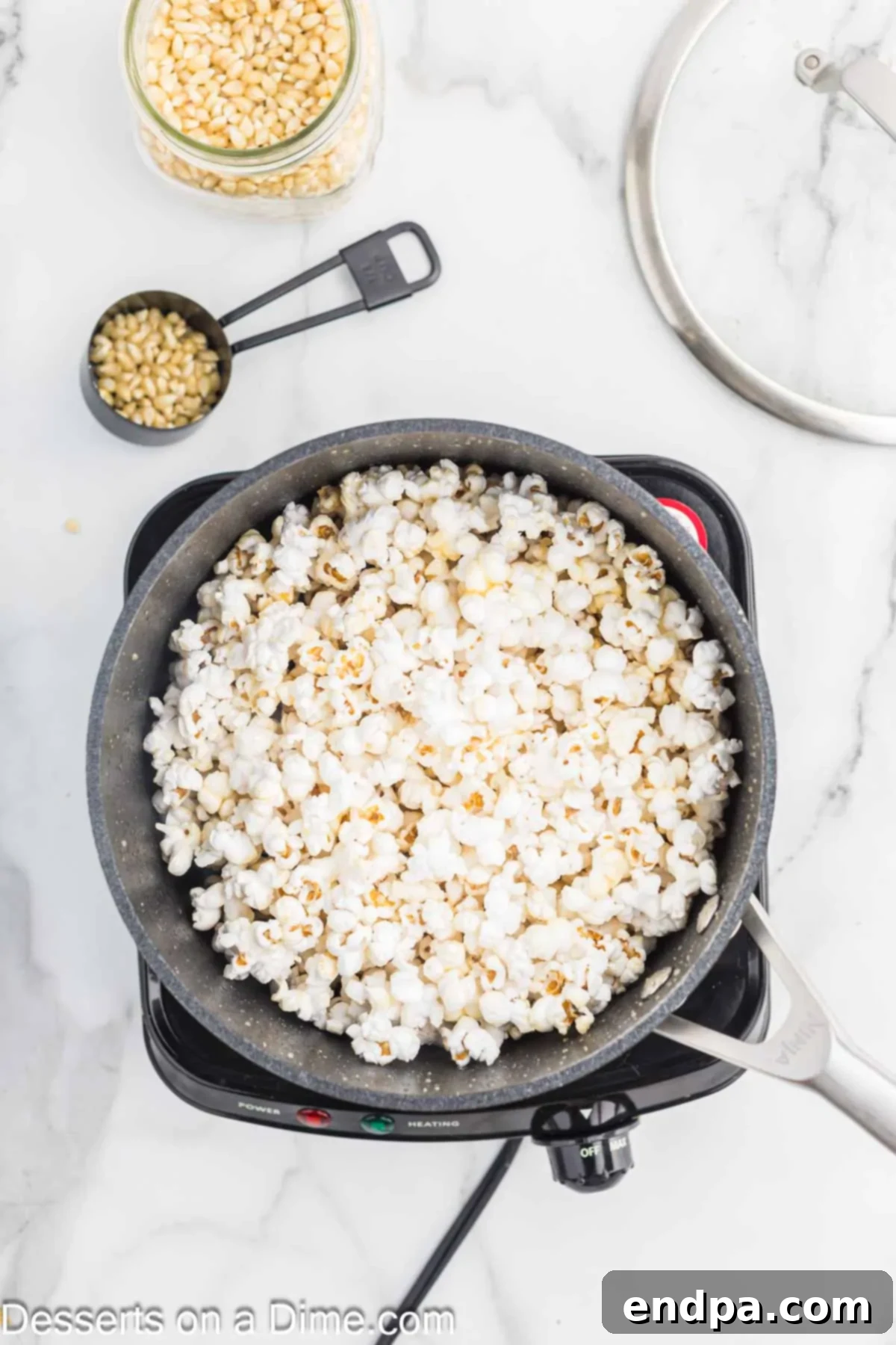 Sweet & Salty Kettle Corn 6 Popcorn actively popping inside a covered saucepan on the stovetop.