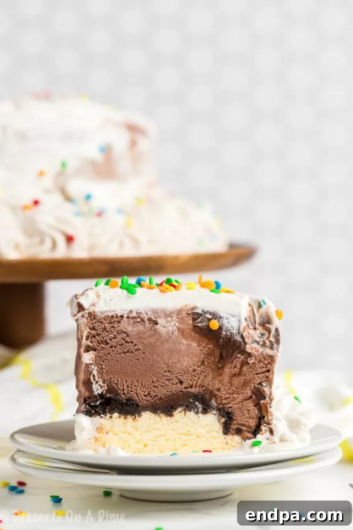 Discover the Layers of Perfection: Your Homemade DQ Ice Cream Cake A close-up view of a perfect slice of homemade Dairy Queen Ice Cream Cake on a white plate, showcasing the distinct layers of ice cream, fudge, and cookie crumbs.