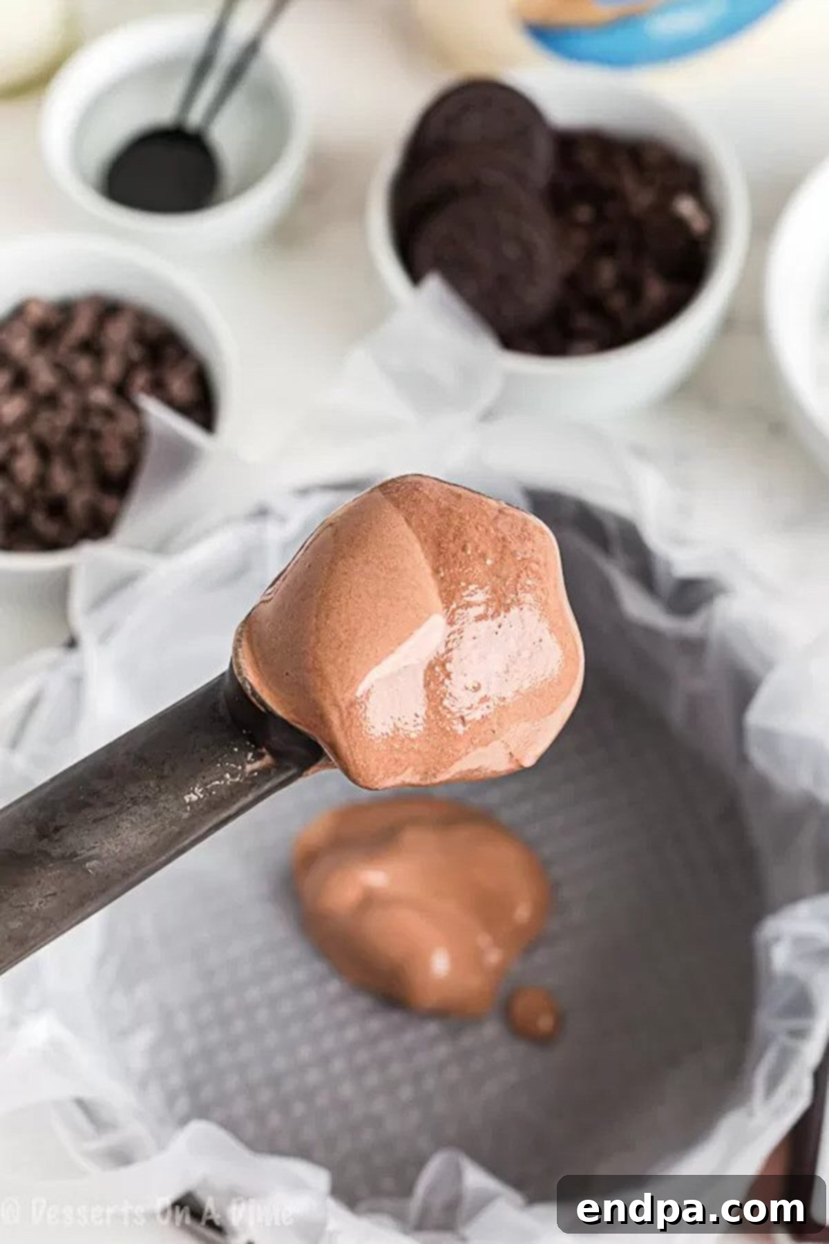 The Ultimate Homemade Ice Cream Cake 2 Softened chocolate ice cream being spread evenly into the plastic-lined cake pan, ready for the freezer.