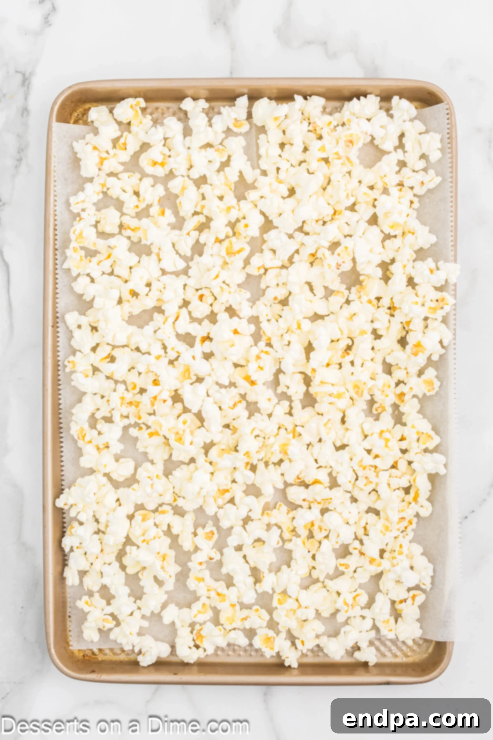 Oreo Popcorn Crunch 4 Popped popcorn on a baking sheet.