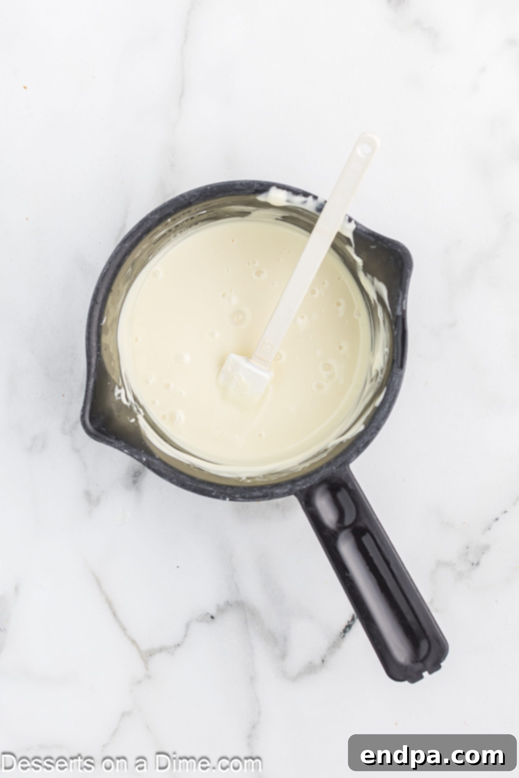 Oreo Popcorn Crunch 6 Melted white chocolate in a saucepan.