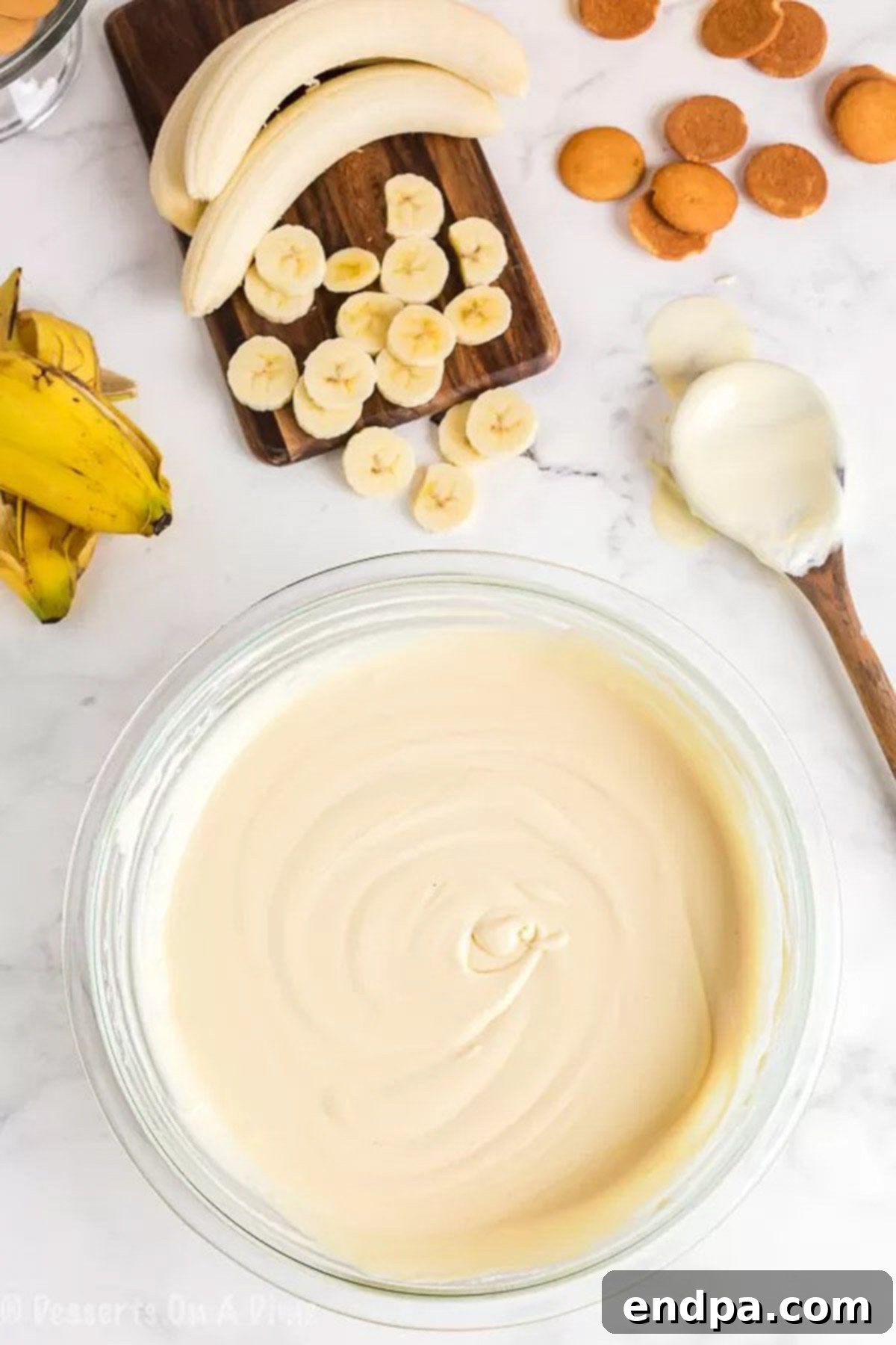 Close-up image of sweetened condensed milk and water being mixed together in a large bowl.