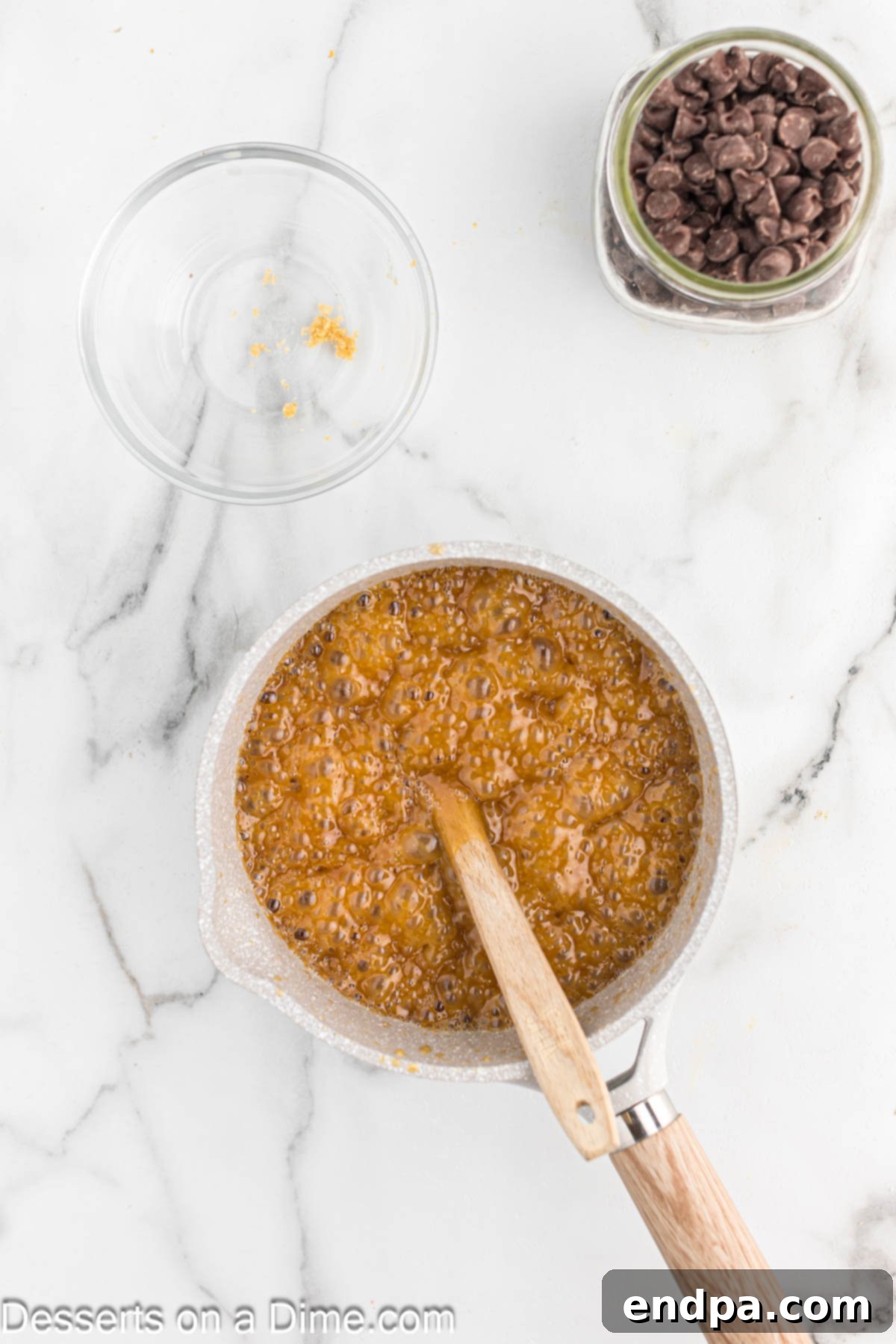 The butter and brown sugar mixture boiling vigorously in a saucepan, forming the crucial toffee layer for the Christmas Crack candy.