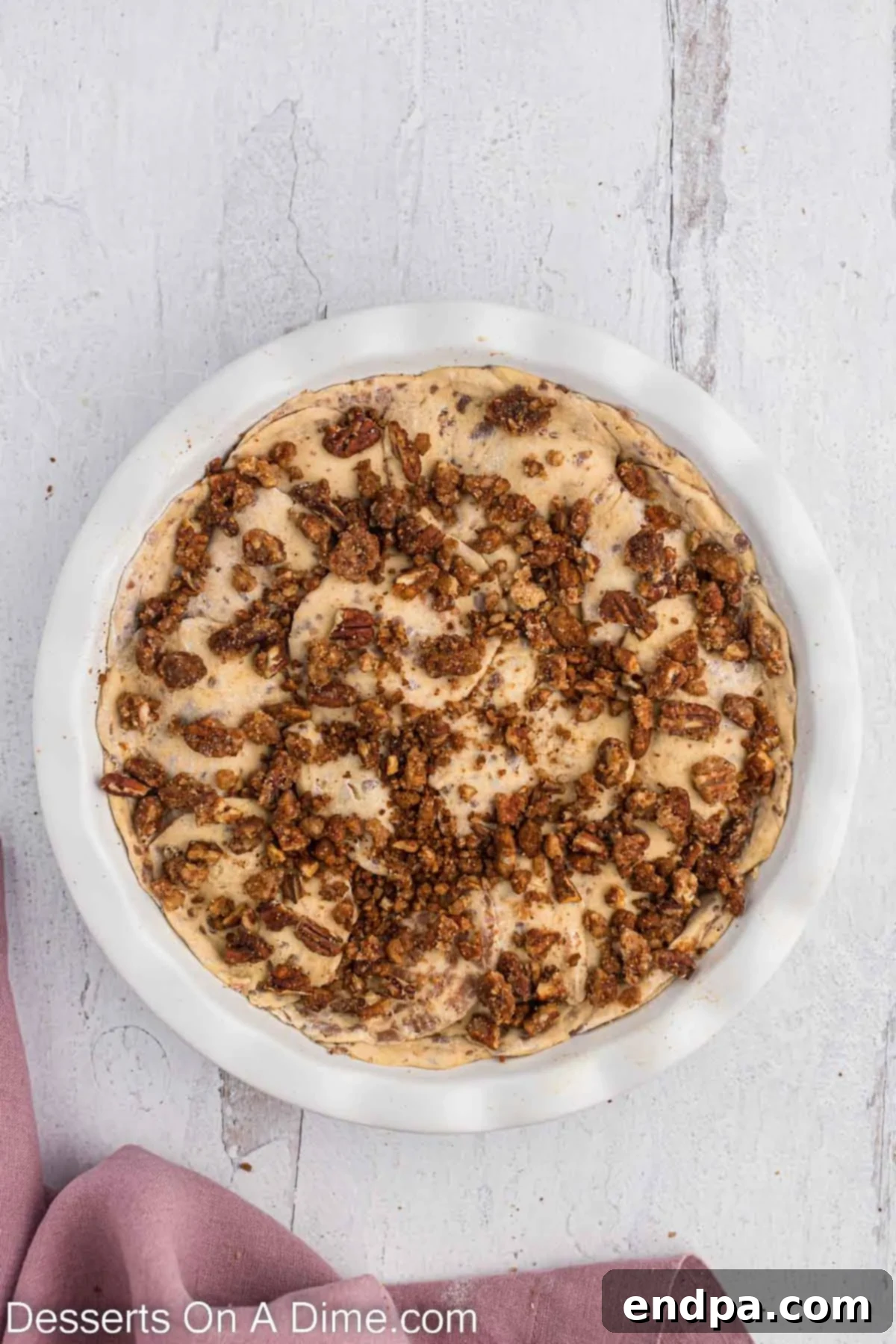 Homemade Cinnamon Roll Pie 11 The last portion of the brown sugar pecan filling sprinkled generously over the top cinnamon roll layer, ready for baking.