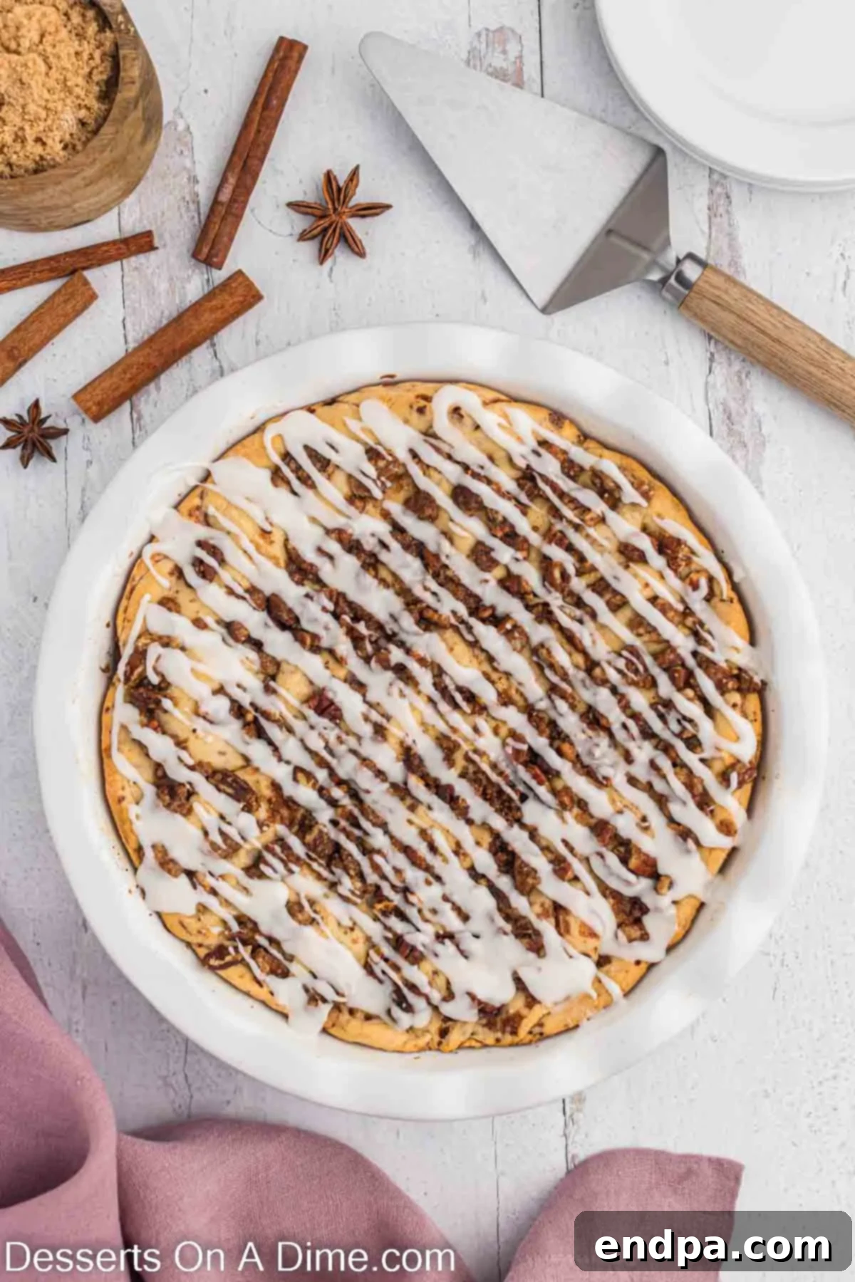 Homemade Cinnamon Roll Pie 13 A finished Cinnamon Roll Pie with a generous drizzle of white icing, ready to be served.