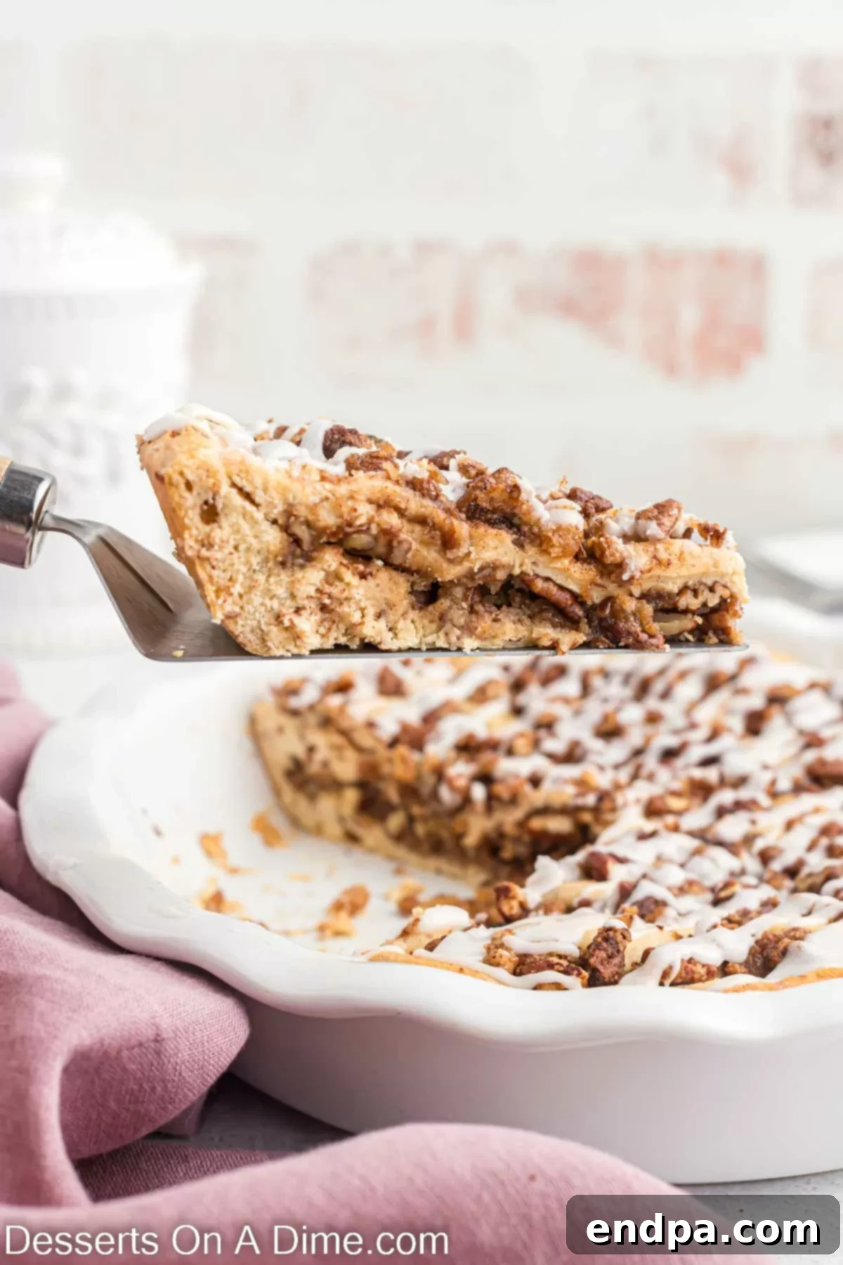 Homemade Cinnamon Roll Pie 14 A perfectly portioned slice of Cinnamon Roll Pie, showcasing its layered crust, pecan filling, and sweet glaze, ready to be enjoyed.