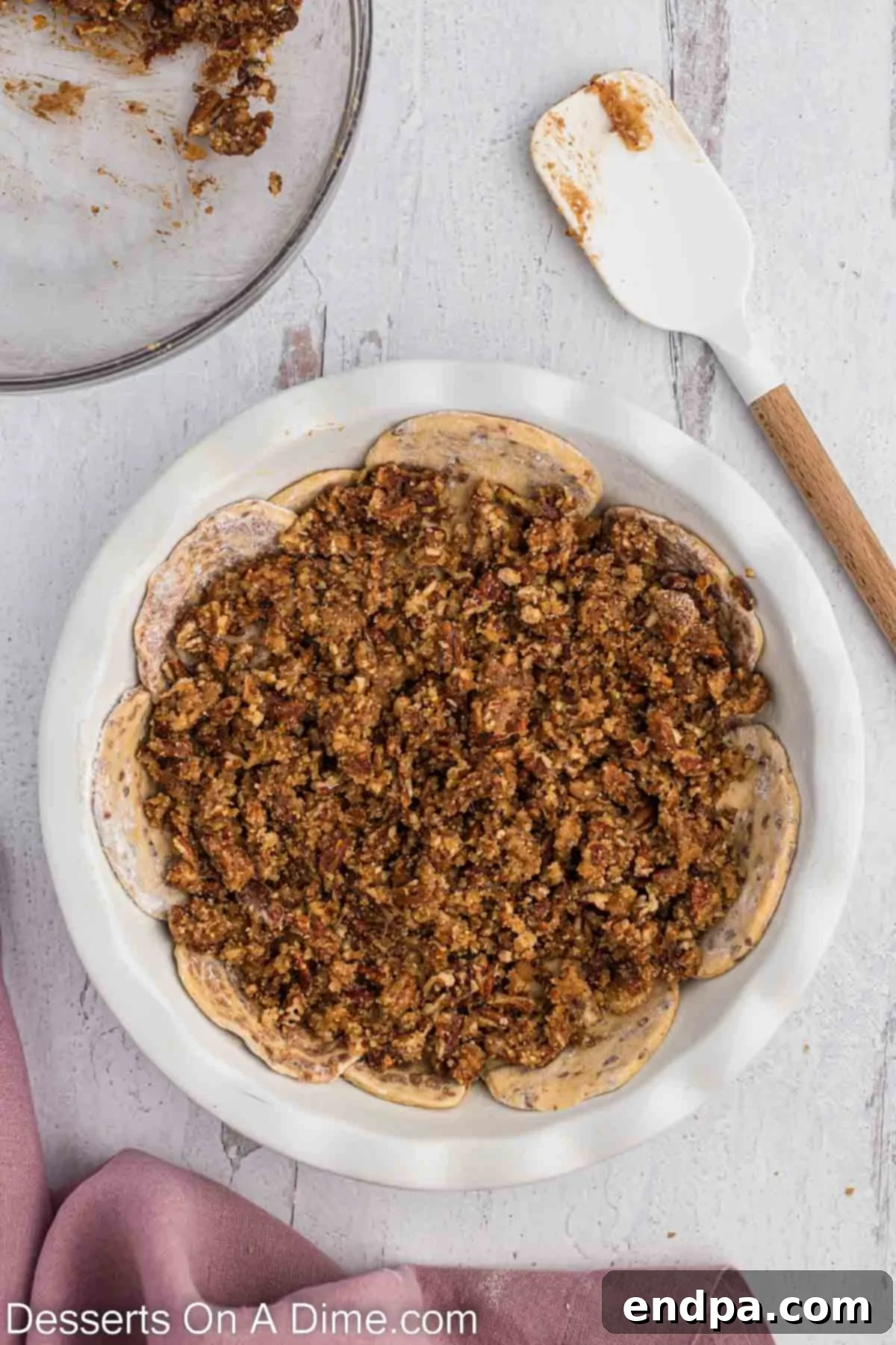 Homemade Cinnamon Roll Pie 9 A portion of the brown sugar pecan mixture evenly spread over the cinnamon roll bottom crust in the pie plate.
