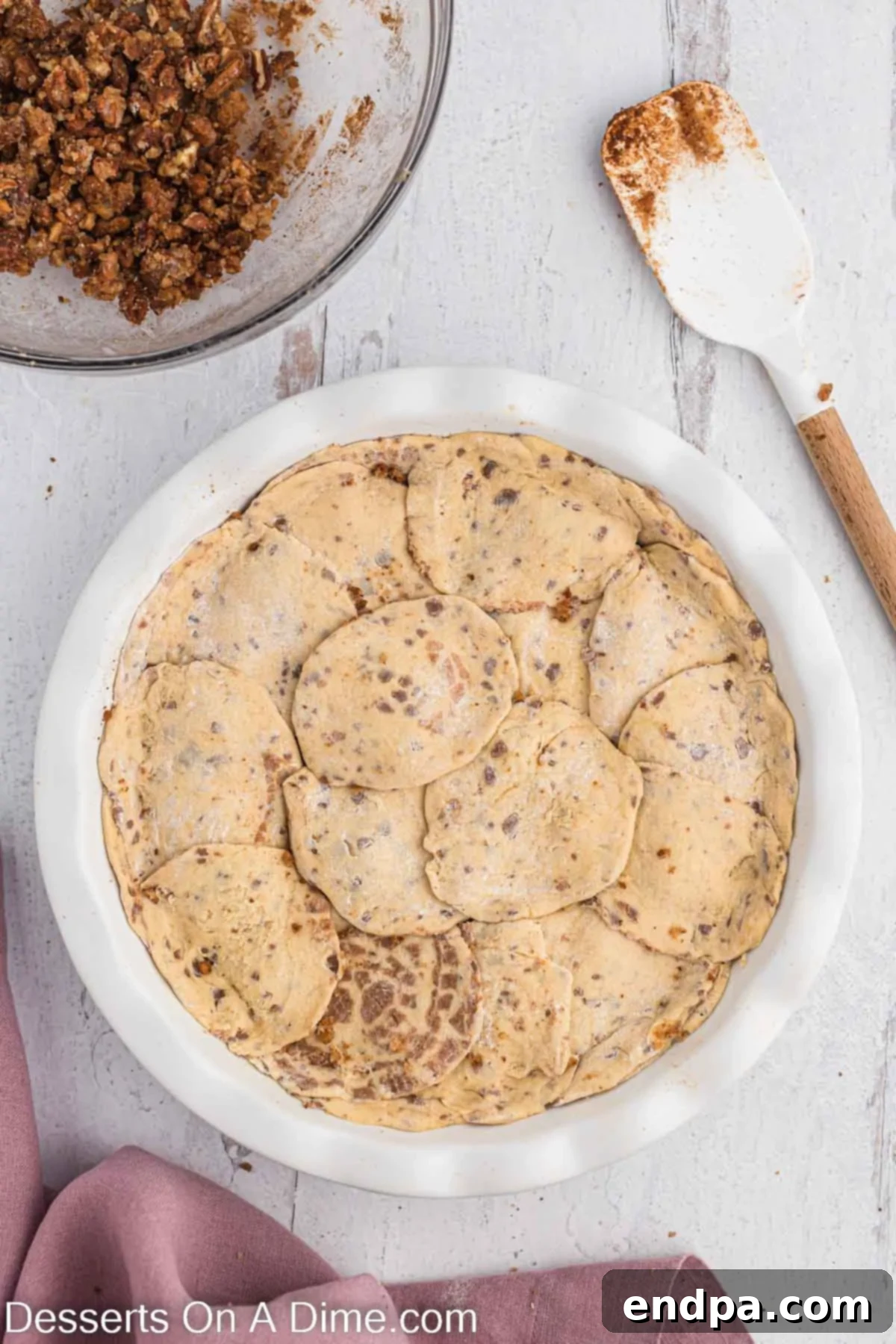 Homemade Cinnamon Roll Pie 10 The remaining cinnamon roll dough artfully placed on top of the pecan filling, creating the pie's top crust.