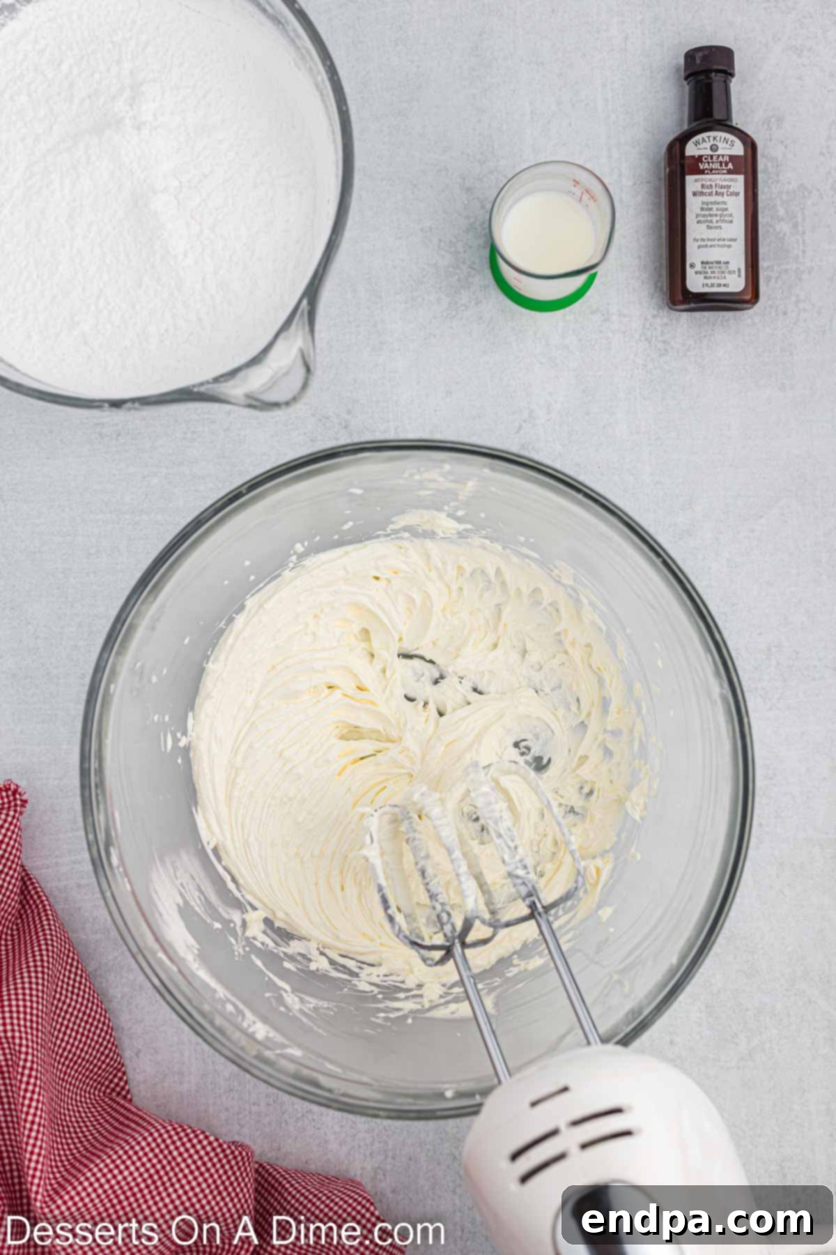 A large mixing bowl containing softened butter and solid vegetable shortening, being combined with an electric mixer until light, fluffy, and smooth.