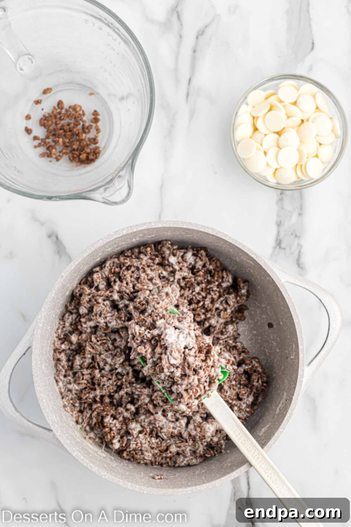 Cocoa Rice Krispies cereal being added to the melted butter and marshmallow mixture in a saucepan.