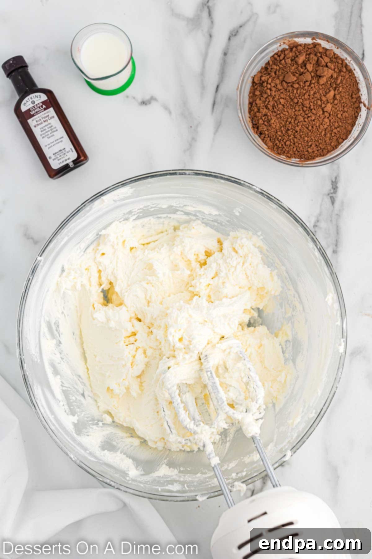 Kick-Off Cupcakes 6 Powdered sugar being gradually added to the butter and shortening mixture in a bowl.