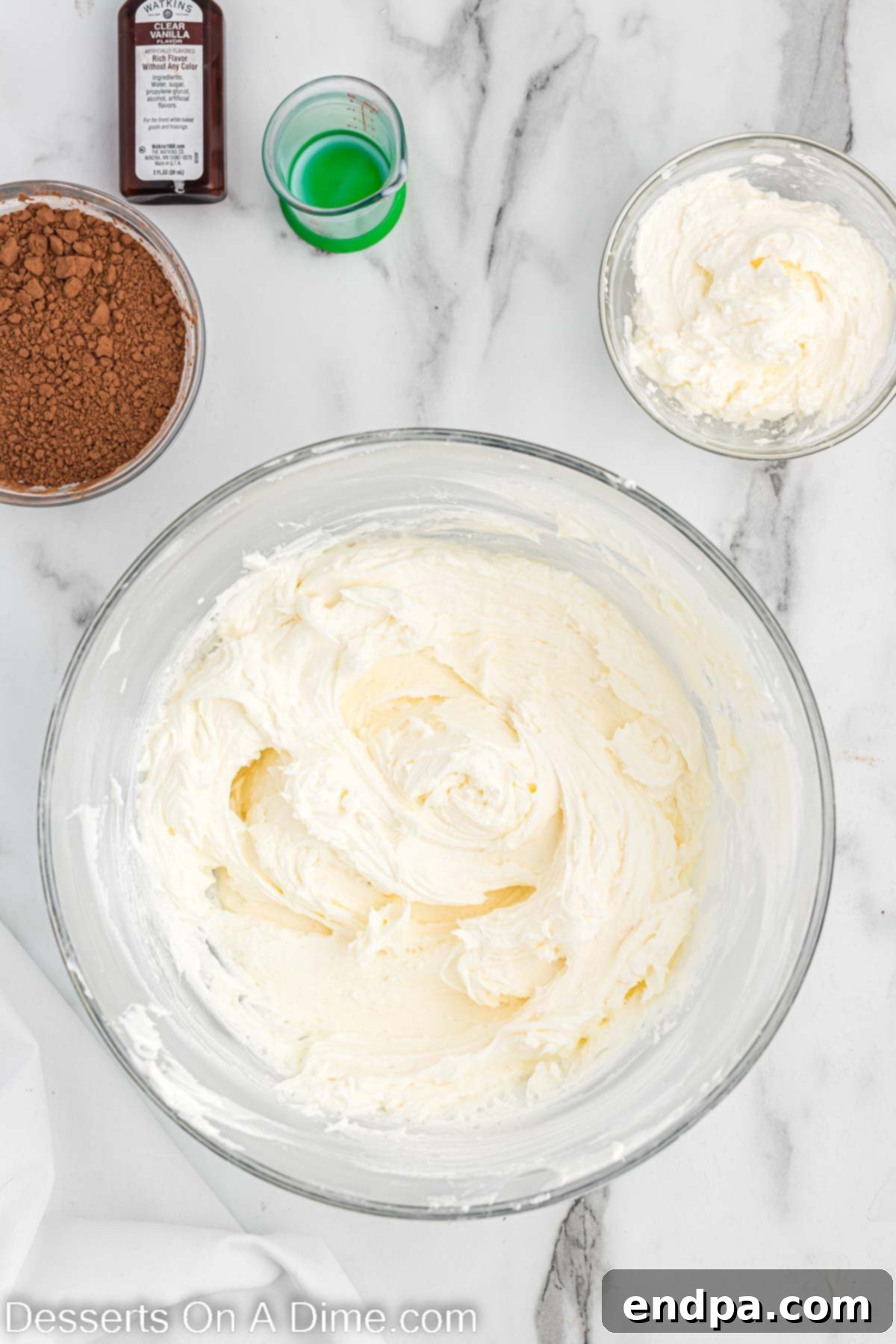 Kick-Off Cupcakes 7 Clear vanilla extract being mixed into the bowl of buttercream frosting.