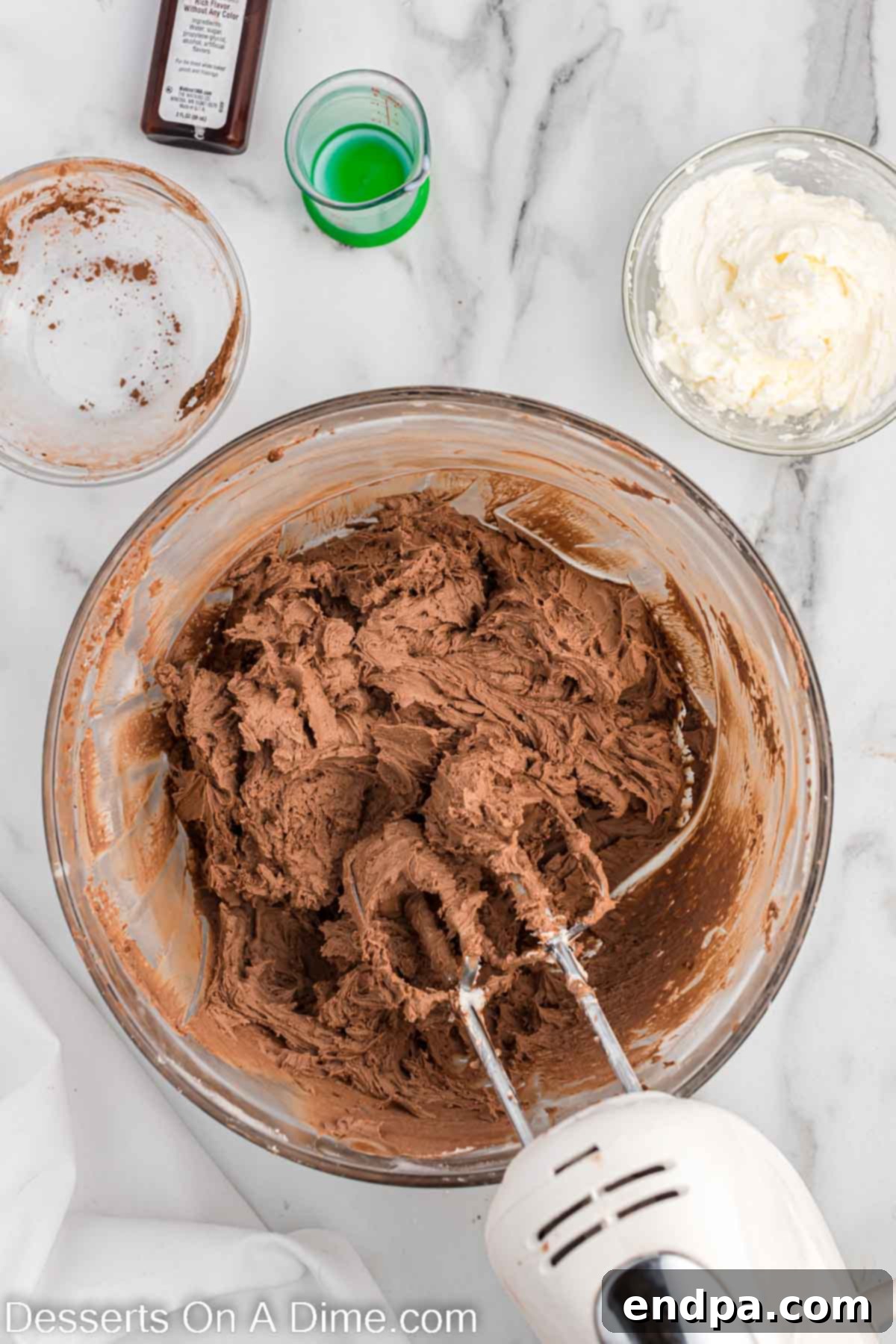 Kick-Off Cupcakes 8 Cocoa powder being added to a portion of the frosting and mixed to create brown football frosting.