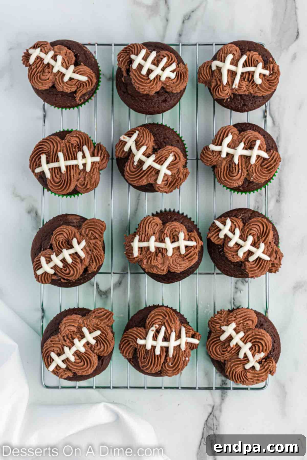 Kick-Off Cupcakes 10 White icing being piped onto each chocolate-frosted cupcake to form the football laces.